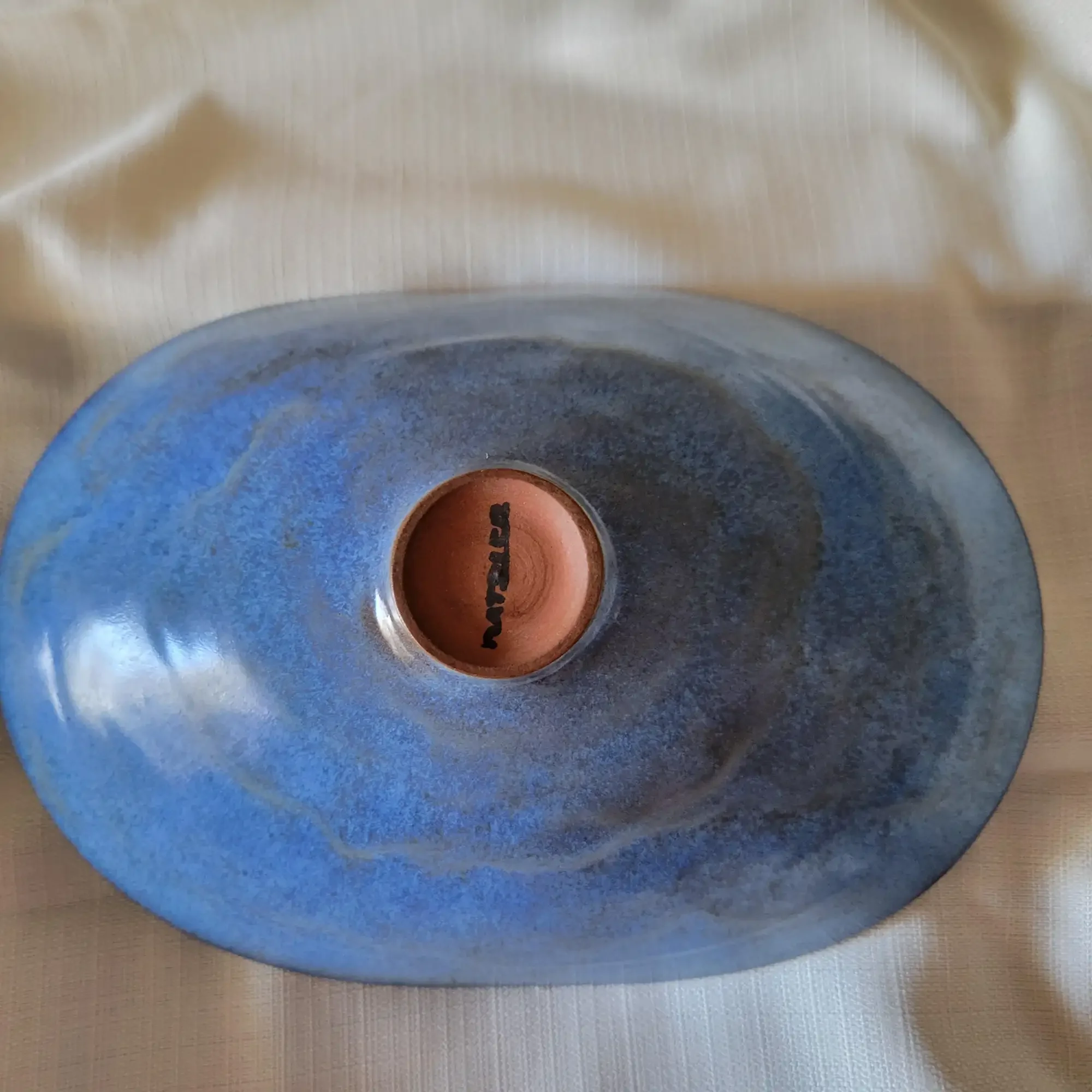Underside of Otto and Gertrud Natzler oval bowl showing robin’s-egg blue glaze and the Natzler signature impressed into the foot.