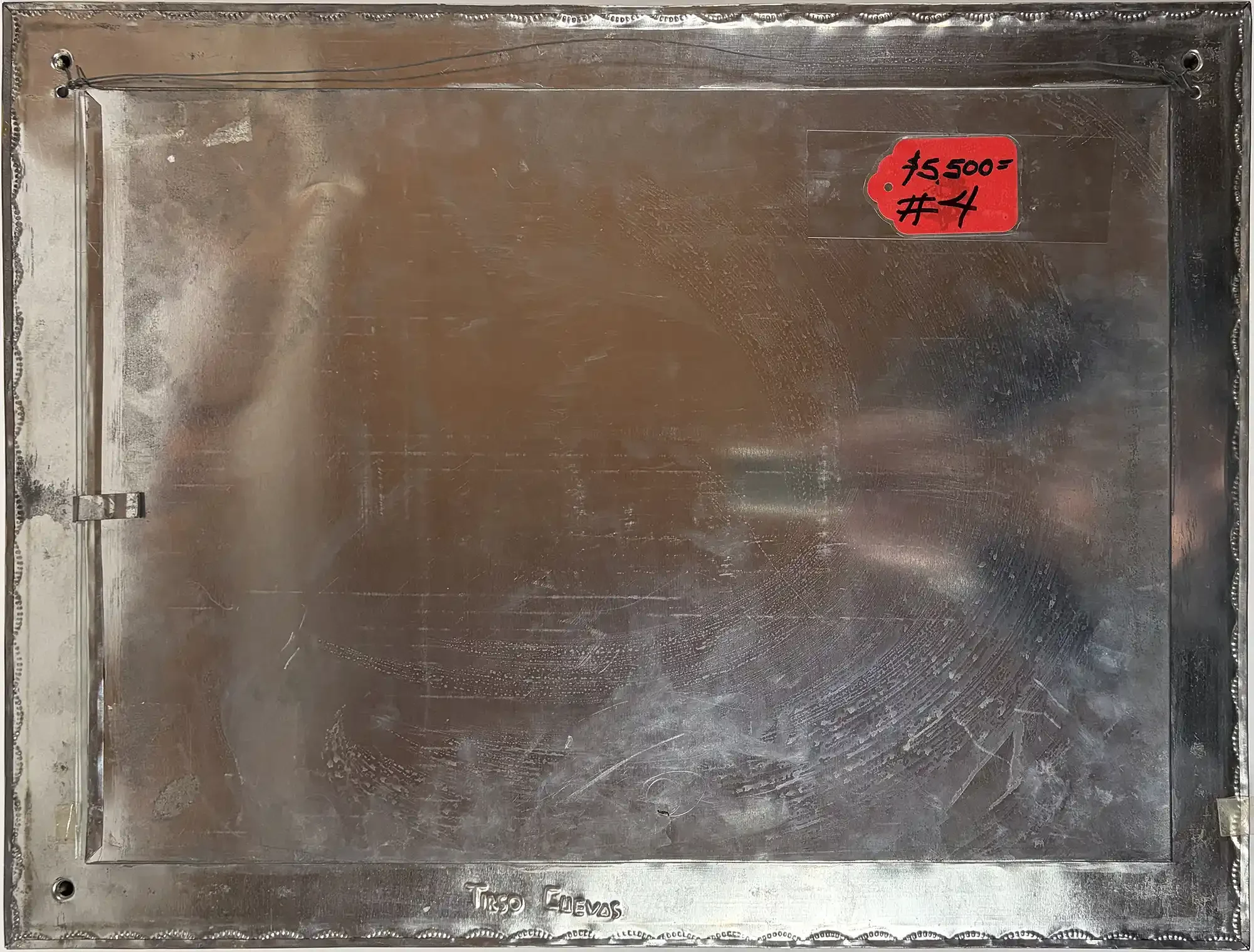 The reverse side of hand-tooled tin frame stamped Tirso Cuevas.