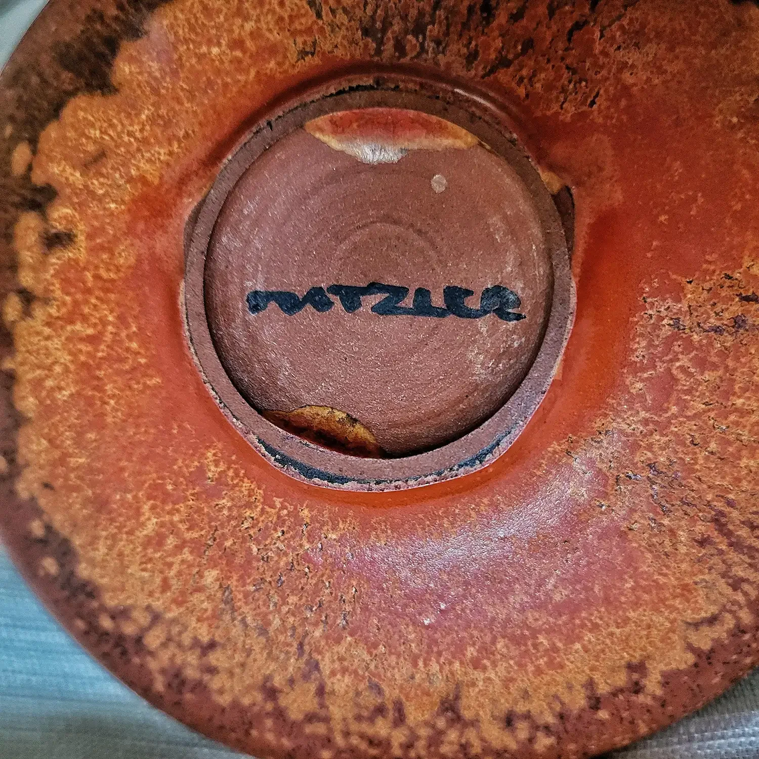 Top view of Natzler Red Desert bowl with radiating crater-red glaze and textured center.