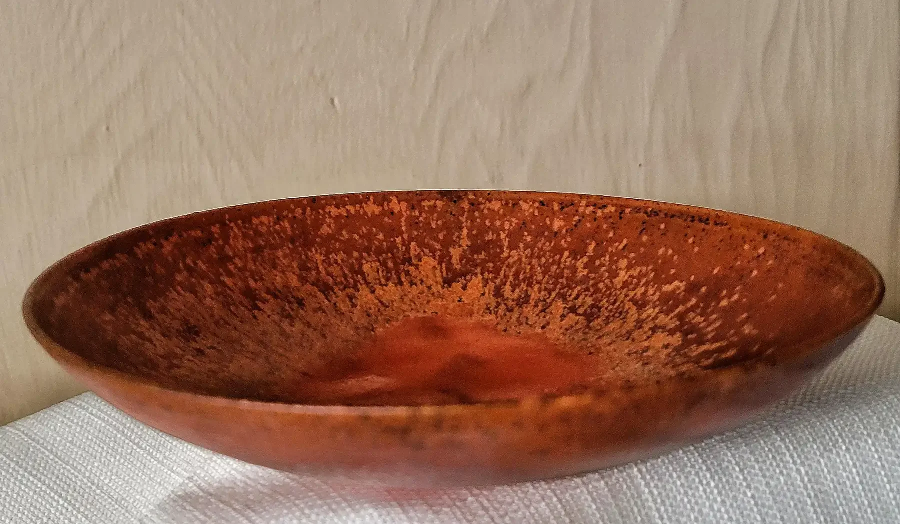 Underside of Otto and Gertrud Natzler bowl showing Natzler signature and crater-red glaze.