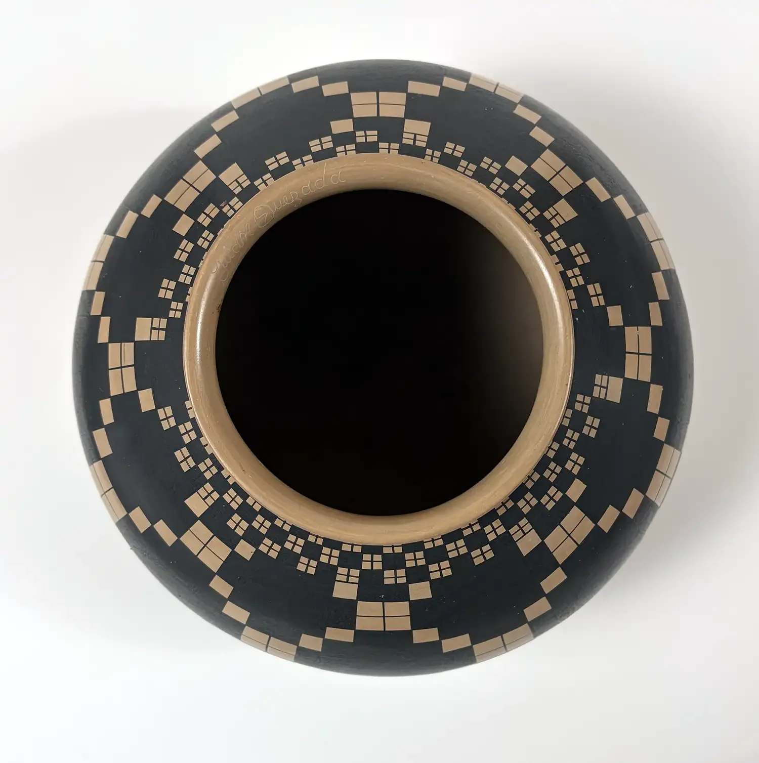 Top view of Juan Quezada black-on-white olla showing concentric stepped and square-grid motifs around the opening.