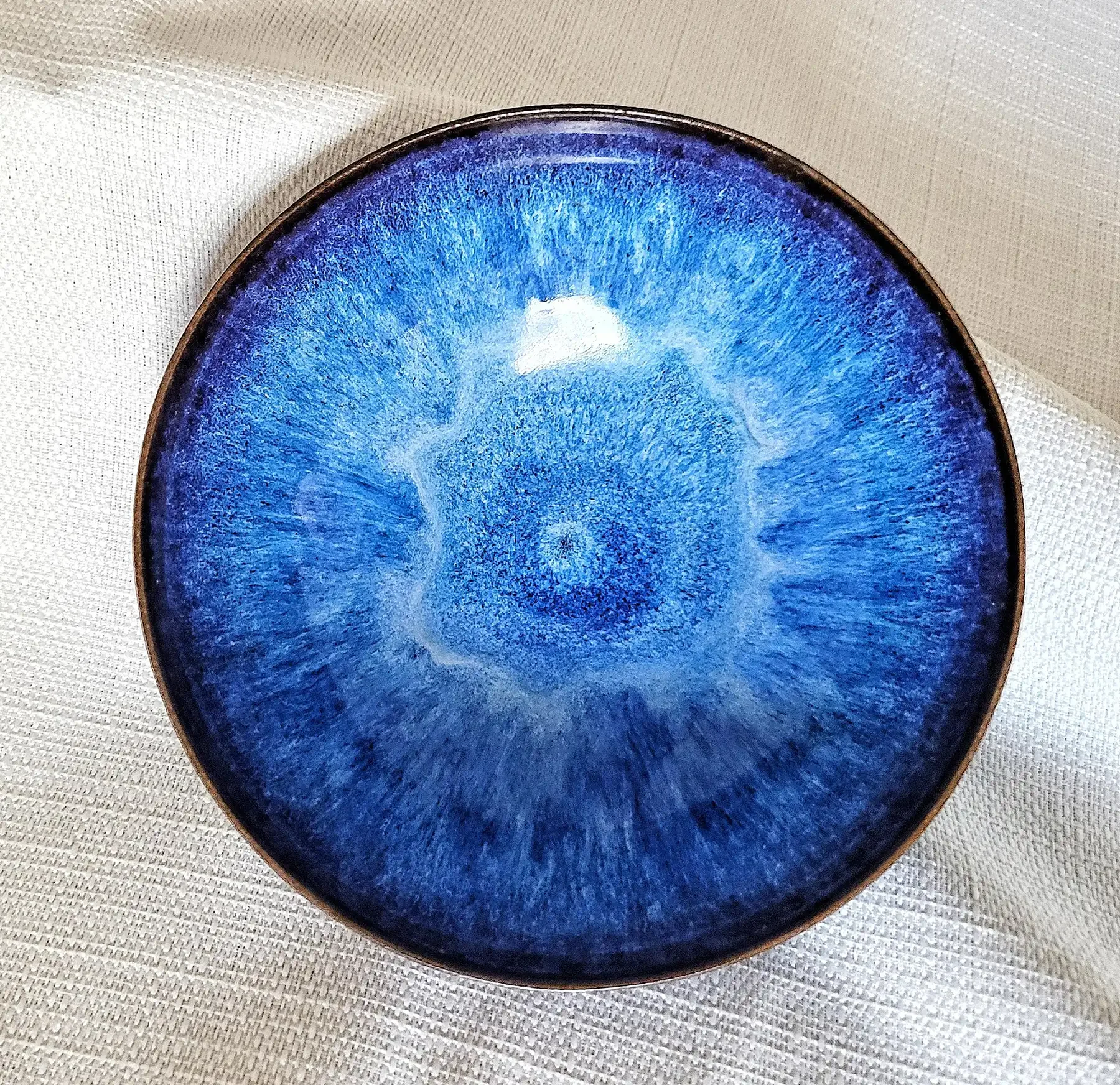 "Top view of a Gertrud and Otto Natzler bowl with Blue Hare’s Fur glaze showing radiant cobalt and sky-blue crystalline striations."