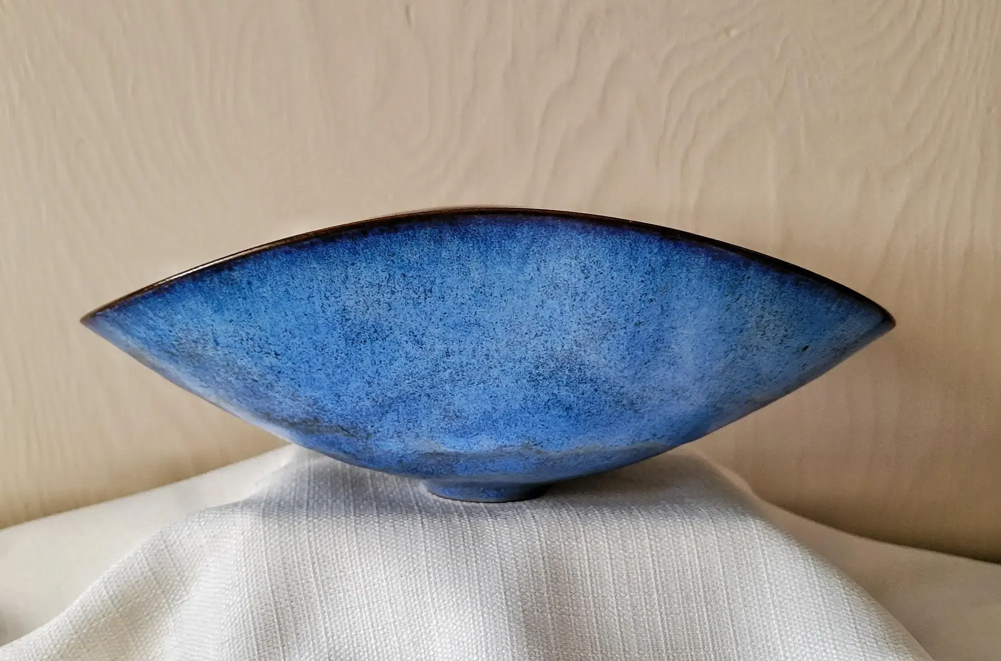 Side view of Otto and Gertrud Natzler’s robin’s-egg blue ceramic bowl, emphasizing the thin walls, curved profile, and rich blue glaze surface.