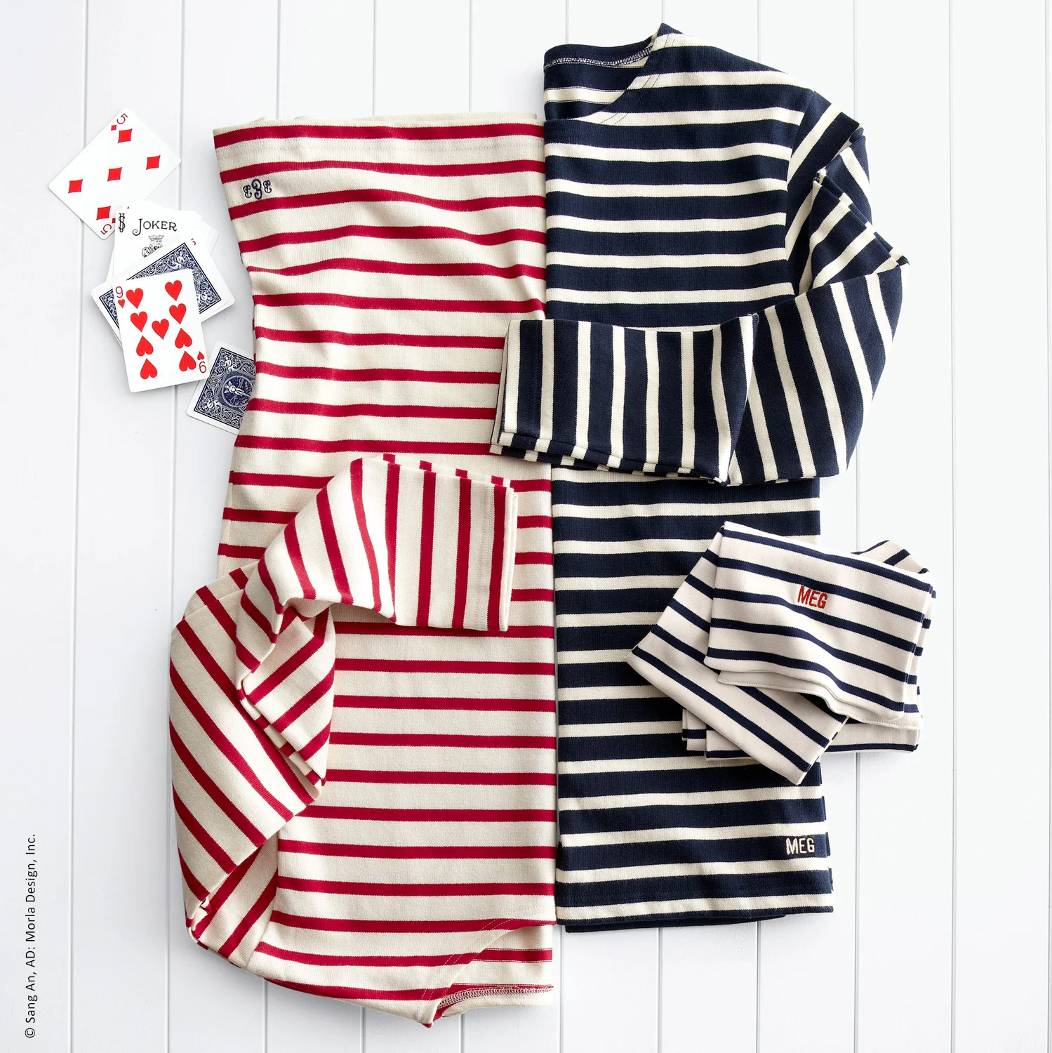 Laydown apparel photo of red, navy & white striped scarf and dresses on a wood set for Williams-Sonoma, Inc.