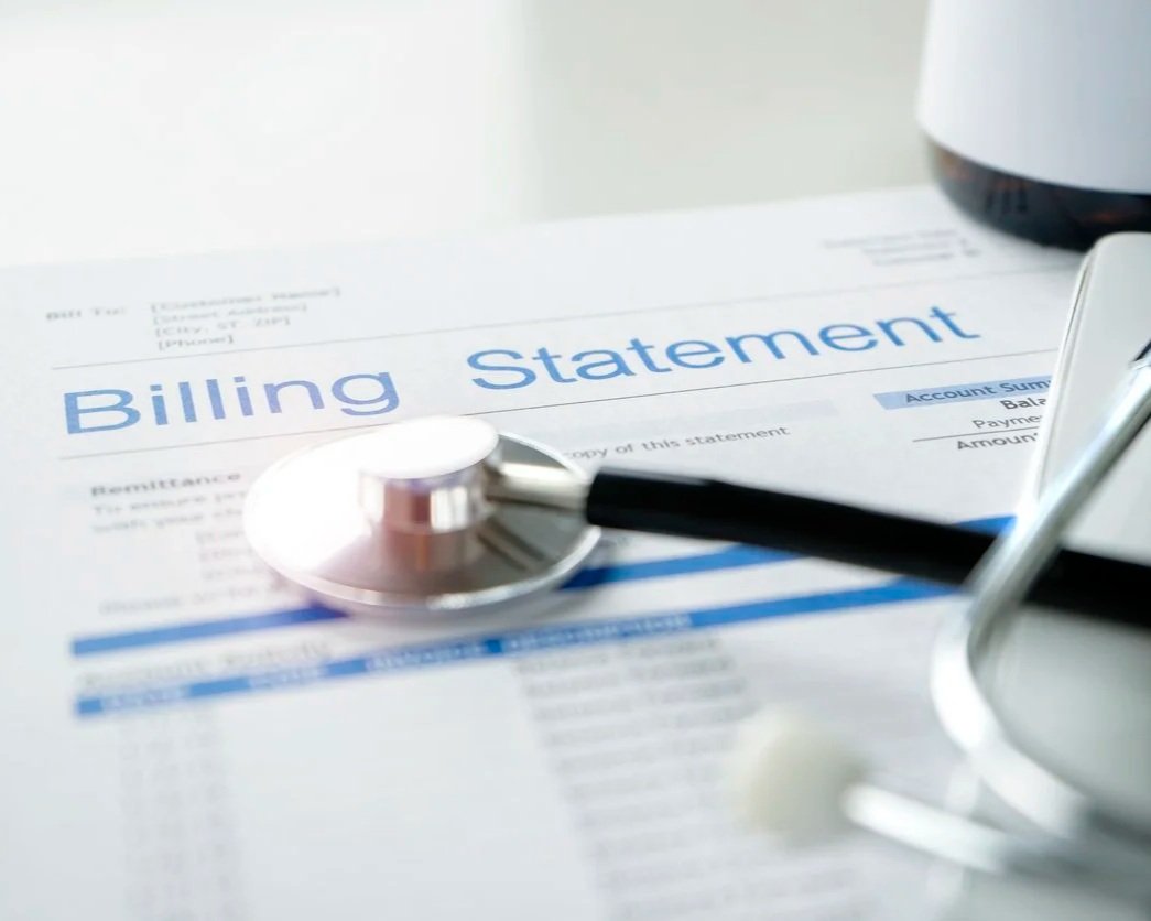 A document titled 'Billing Statement' on a desk, with a stethoscope partially resting on it and other medical equipment nearby.