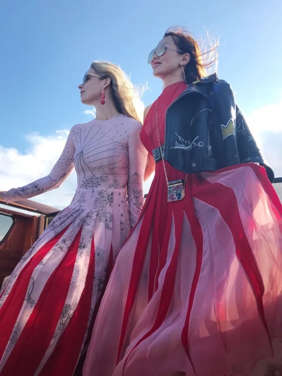 Arriving by boat with Tina Craig (right), dressed in Valentino.