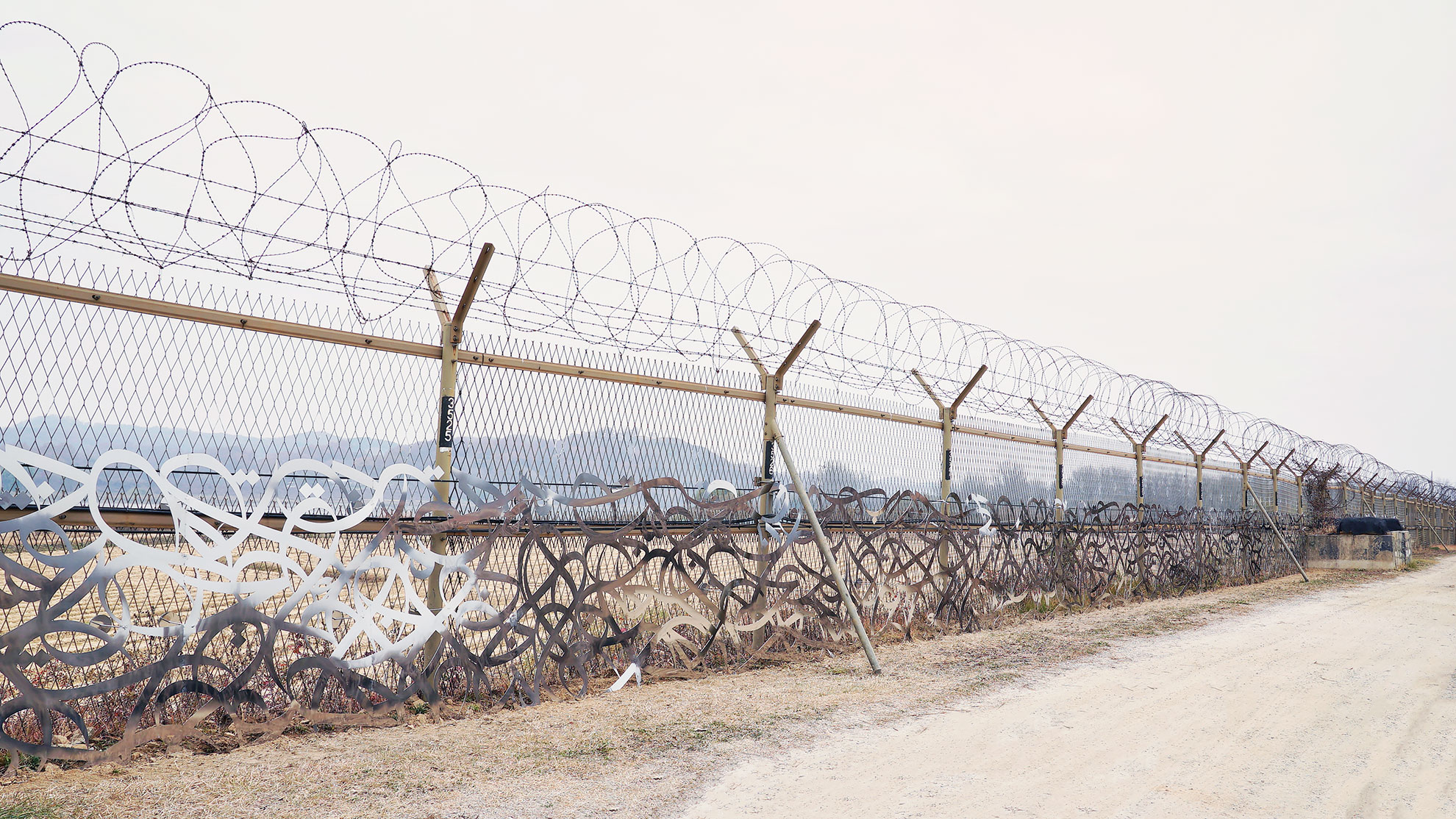  The barbed wire fence between North and South Korea represents discord and violence. eL Seed's artwork is a message of unity. 