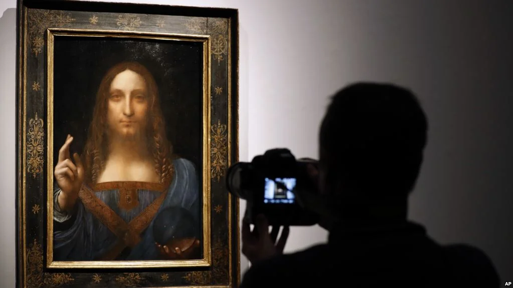 A visitor films Leonardo da Vinci's "Salvator Mundi" on display at Christie's auction rooms, in London, Oct. 24, 2017. Image Credit: AP