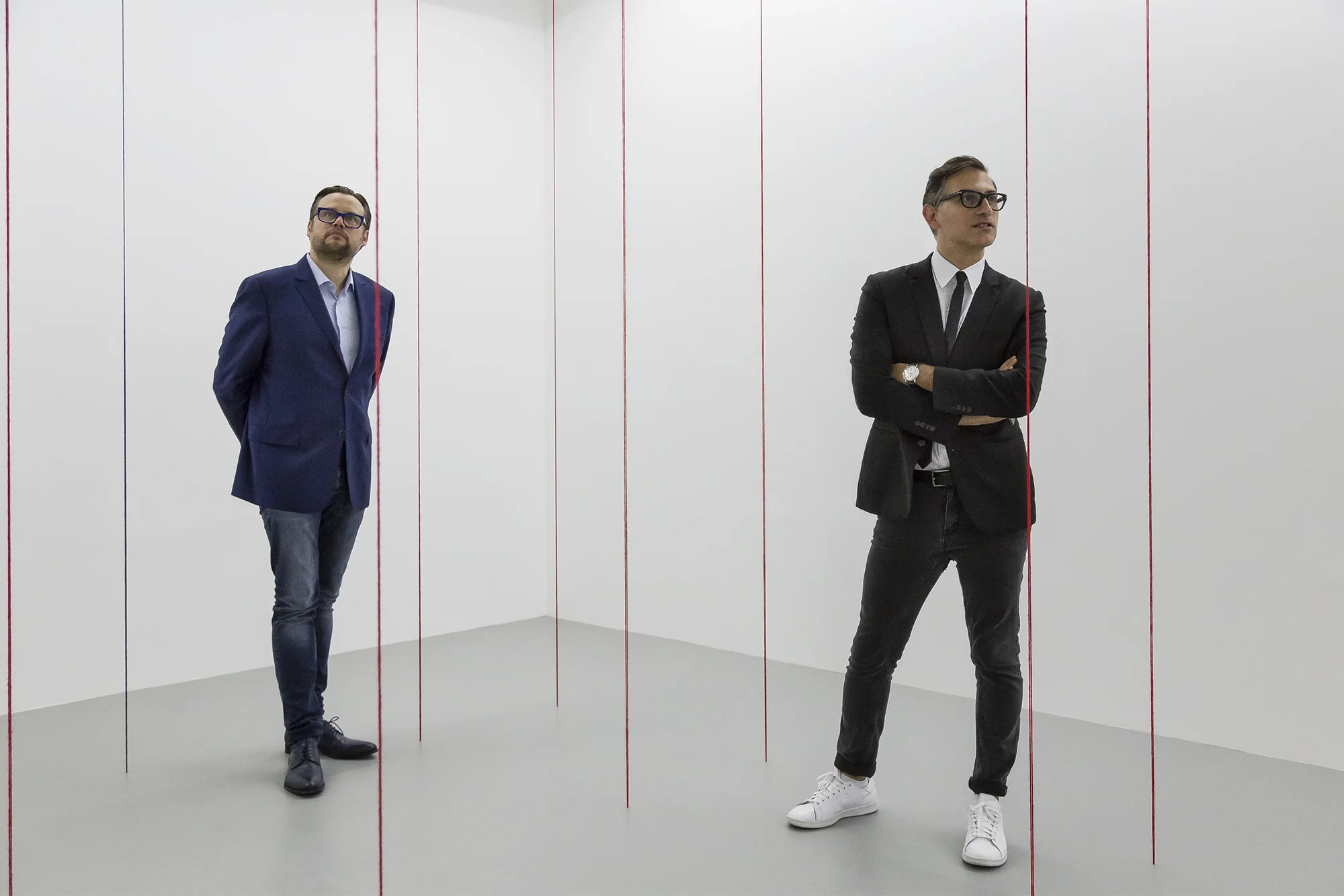 Sam Bardaouil & Till Fellrath stand inside Fred Sandback’s work inside their Ways of Seeing exhibition.