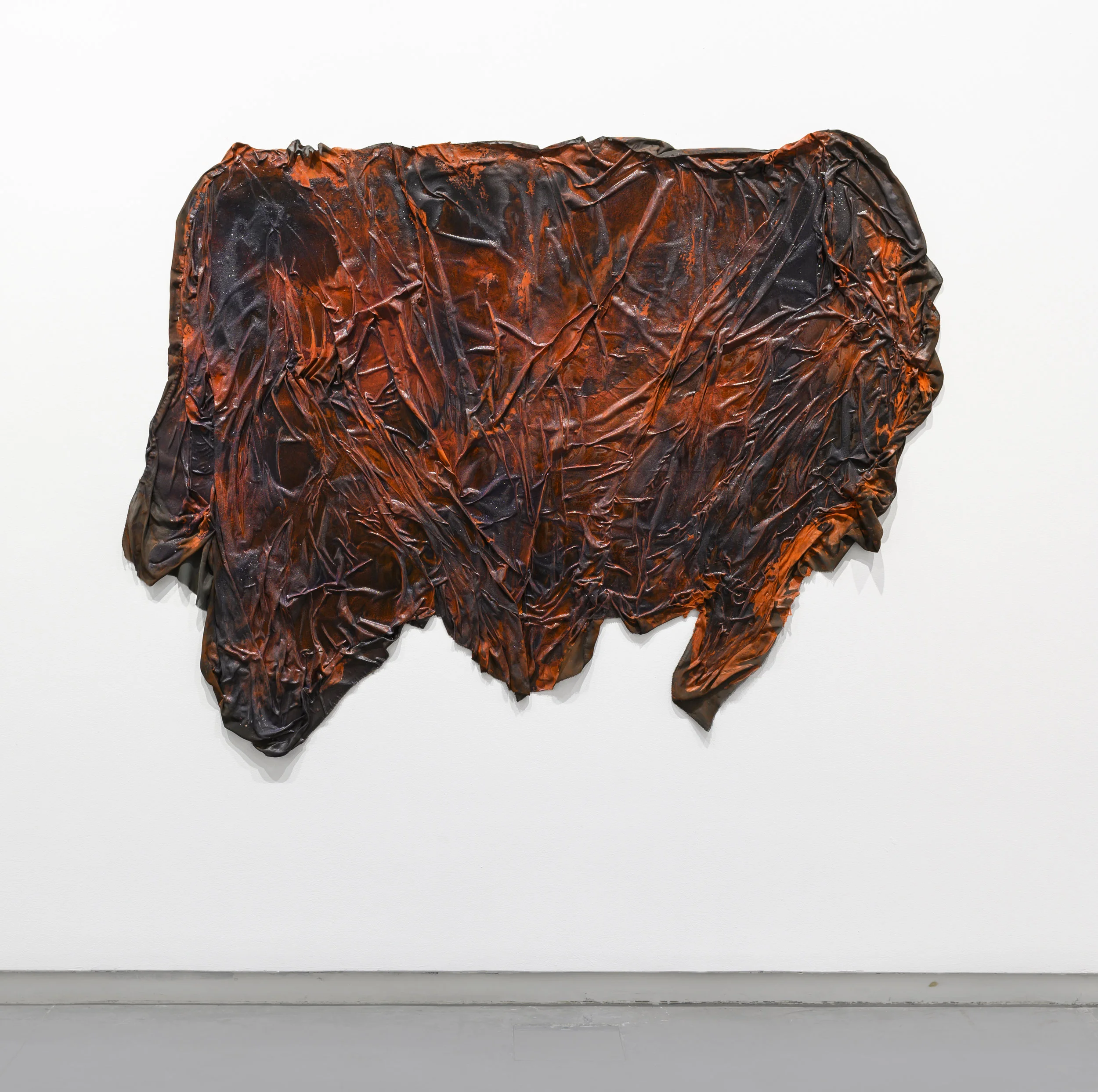 Dala Nasser, Red is the colour of everything internal, 2018. Discarded fabric, survival blankets, coal, glitter, liquid latex, resin, chrome orange and DPP orange pigments; 160 x 195 cm. Installation view: Surface Tension, Sharjah Art Foundation, Sharjah, 2019. Courtesy of the artist. Photo: Sharjah Art Foundation
