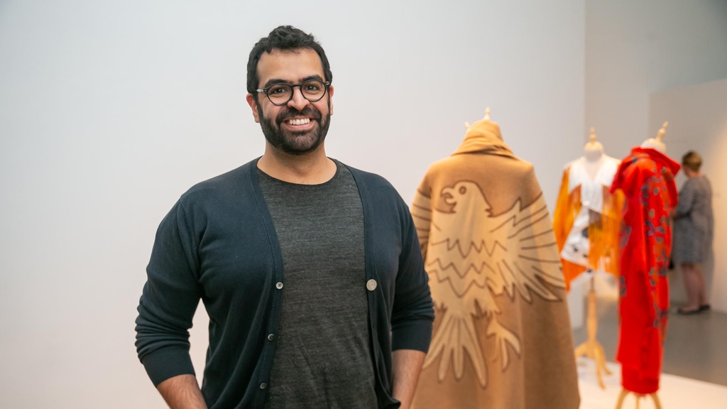 Khalid Mezaina stands infront of his work at Tashkeel's The Alumni Return. He has graduated with a master's degree in textile design from Rhode Island School of Design. Image courtesy of Tashkeel.