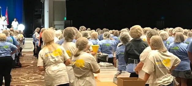 Pilots listen to instructions prior to packing the food into bags Everyone wore caps on their heads, aprons and those who handled the food also wore gloves.