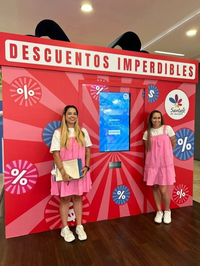 Promotoras junto a la caja de retos con pantalla interactiva