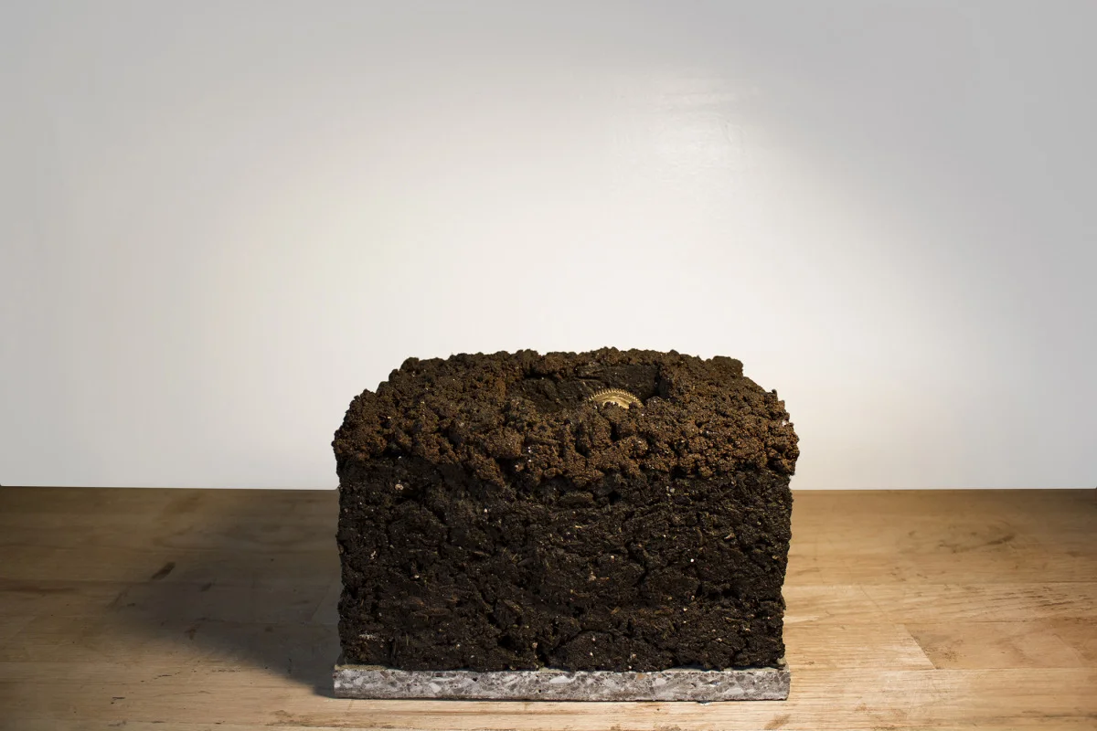    Blocks [Lost/Gained, I Want What's Yours]  Mechanical sculpture with soil, volcanic rock, granite slab, motor, gears, gold leaf, gold watch 10 x 8 x 8 in 2014 view documentation:  https://vimeo.com/84714384   
