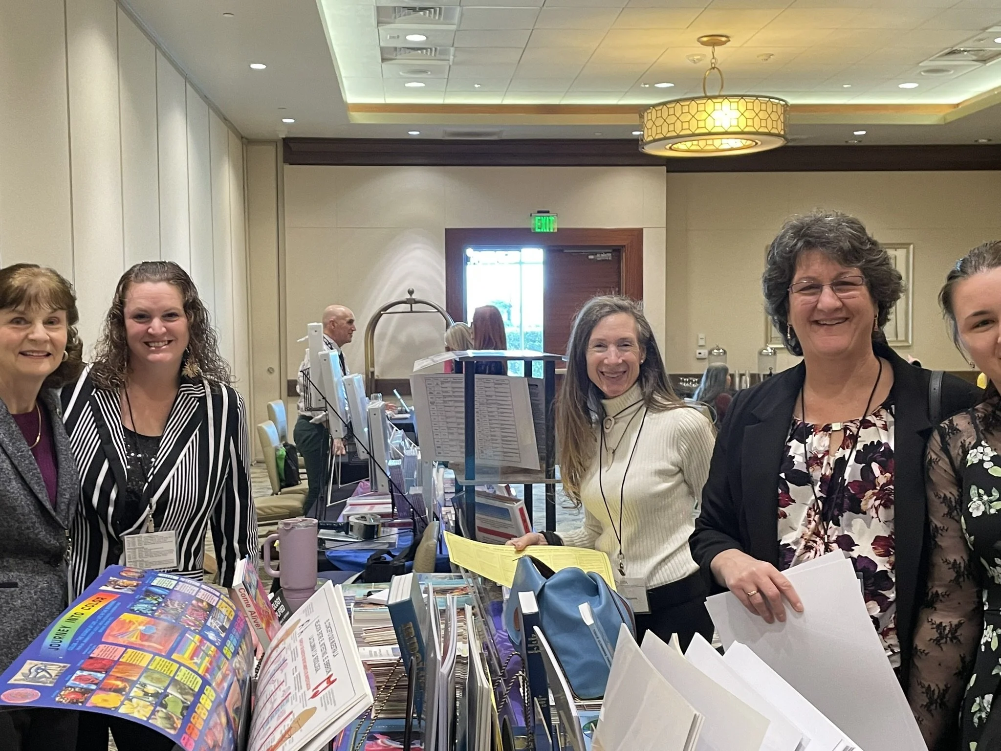 Attendees visiting a vendor table at the International Iridology Practitioners Association Symposium