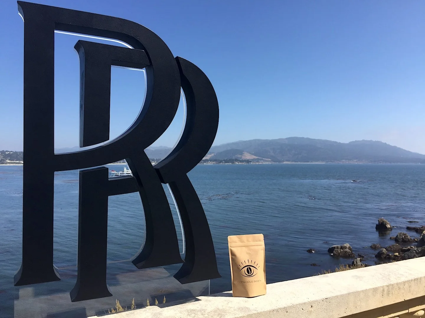 Conscious Bean coffee overlooking the ocean with the Rolls Royce logo at Rolls-Royce Villa in Pebble Beach