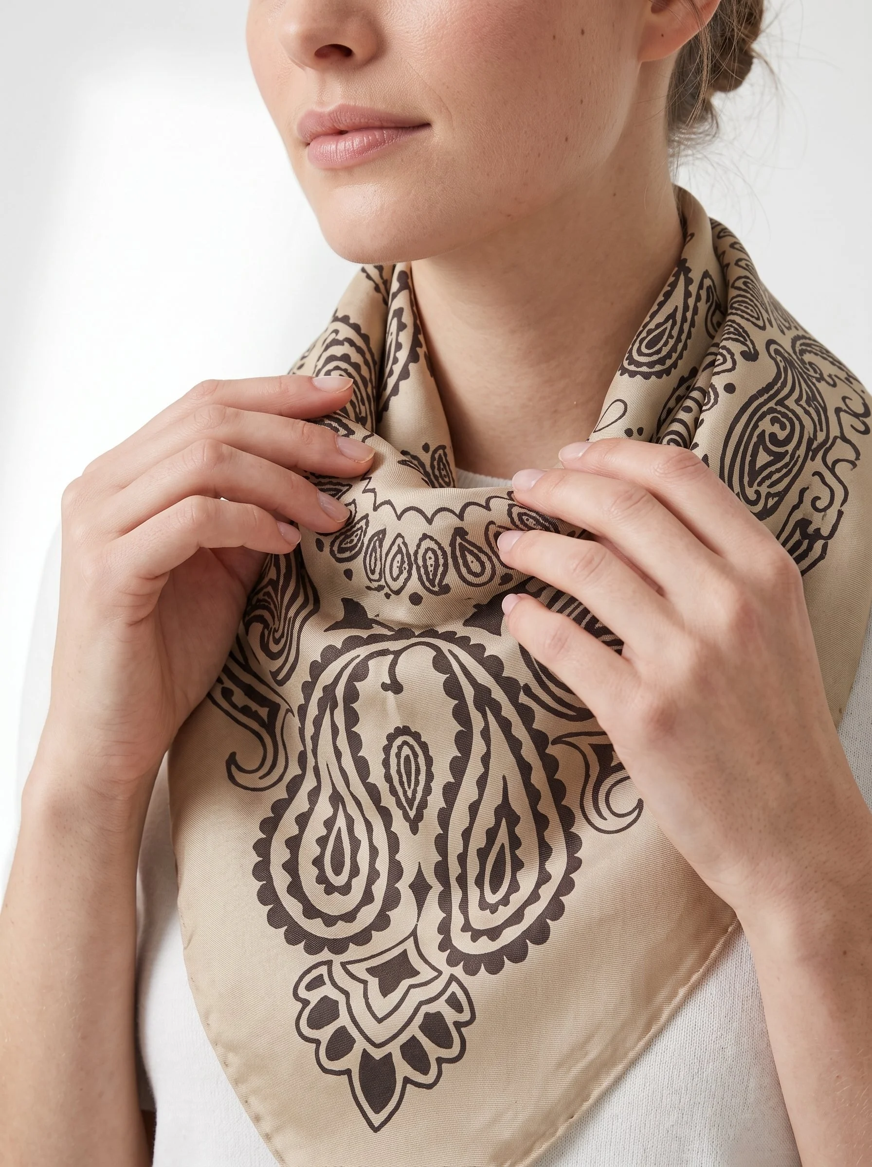 Close detail of the latte beige bandana scarf showing the paisley print register