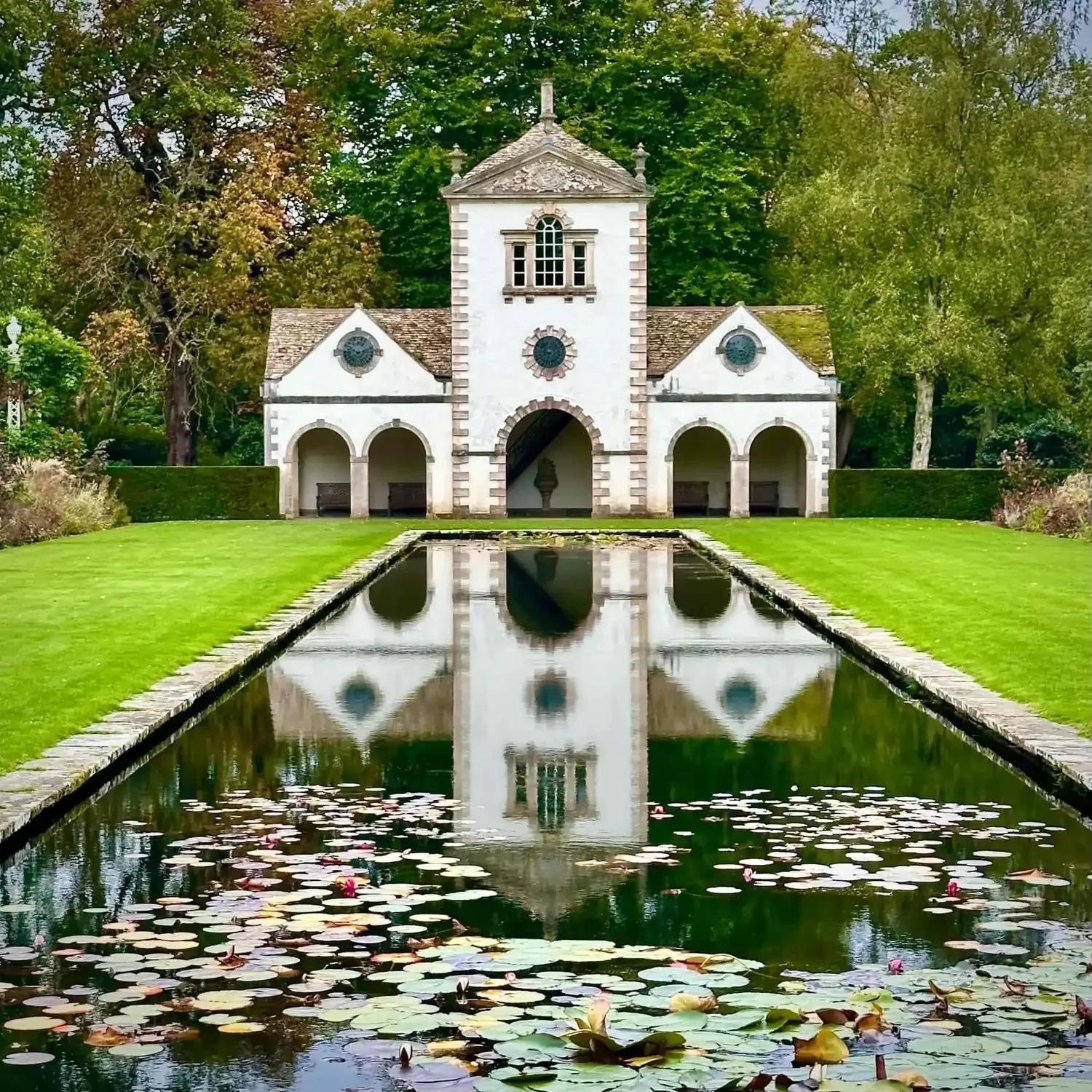 An ornate white building in front of a long pond at Bodnant Garden in Wales