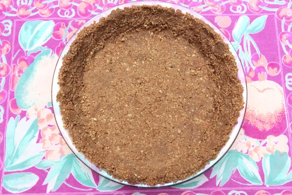 Pat-In Pecan Crust Author: Dédé Wilson Makes: Makes 1, 9-inch pie shell Ingredients 1 cup pecan halves ½ cup Oliver Farm pecan flour 1 tablespoon sugar 2 to 3 tablespoons Oliver Farm Pecan Oil Instructions Position rack in center of oven. Preheat oven to 350°F. Have a 9-inch pie plate ready; no need to grease pan. Place pecan halves, flour and sugar in bowl of food processor fitted with metal blade. Pulse on and off until mixture is coarse ground. Add the smaller amount of oil, pulse on and off again and test. See in second photo above how I have pressed a rubber spatula against the front right portion and it is sticking together? That’s what you want. Only add additional oil if needed. Dump mixture into pie plate and use fingers to press evenly across bottom and up the sides, creating a nice, neat rim. Bake for about 8 to 10 minutes until dry to the touch and just beginning to color. Cool and use in recipe as desired. Bakepedia Tips This crust is very tender and can only be used as a bottom crust, so don’t even think about doubling it and creating a top crust! Images: Dédé Wilson