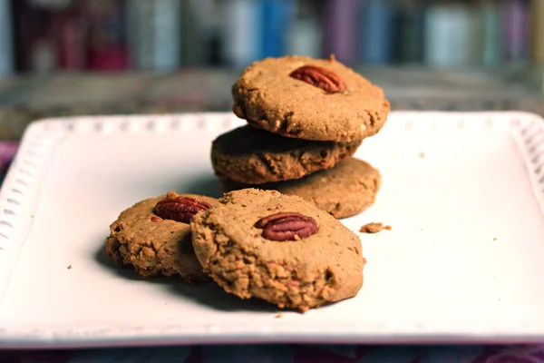 Coffee Pecan Shortbread Cookies Author: Dédé Wilson Makes: Makes 16 cookies Ingredients 1 cup (2 sticks) unsalted butter, at room temperature ⅔ cup firmly packed light brown sugar 2 teaspoons instant espresso powder or instant coffee 2 teaspoons vanilla extract 1½ cups all-purpose flour ½ cup Oliver Farm pecan flour, ½ cup whole pecans, toasted 16 whole pecans for garnish (optional) Instructions Position racks in upper and lower third of oven. Preheat oven to 325°F. Line two baking sheets with parchment paper; set aside. Beat butter with electric mixer until lightened and creamy. Add sugar gradually and beat on high speed until very light and fluffy, about 3 to 5 minutes. Beat in coffee and vanilla. Add the flour and pecan flour and beat just until combined. Beat in chopped pecans. Drop cookie dough in scant ¼-cup amounts on baking sheet 2-inches apart. Bake for about 15 to 20 minutes, or until the cookie tops are dry and the bottoms are just turning light brown. Place pans on racks to cool. Store in airtight container for up to four days. Bakepedia Tips These cookies can be finished off nicely with a drizzle of bittersweet chocolate. Have cooled cookies on pan. Melt 4 ounces semisweet or bittersweet chocolate, place in parchment cone, making a tiny opening in the tip. Drizzle the chocolate, sweeping your arm back and forth to make lines all over the cookies. Place pans in refrigerator for 5 minutes to harden chocolate. Store at room temperature for 1 day, or in refrigerator for up to 4. Image Dede Wilson