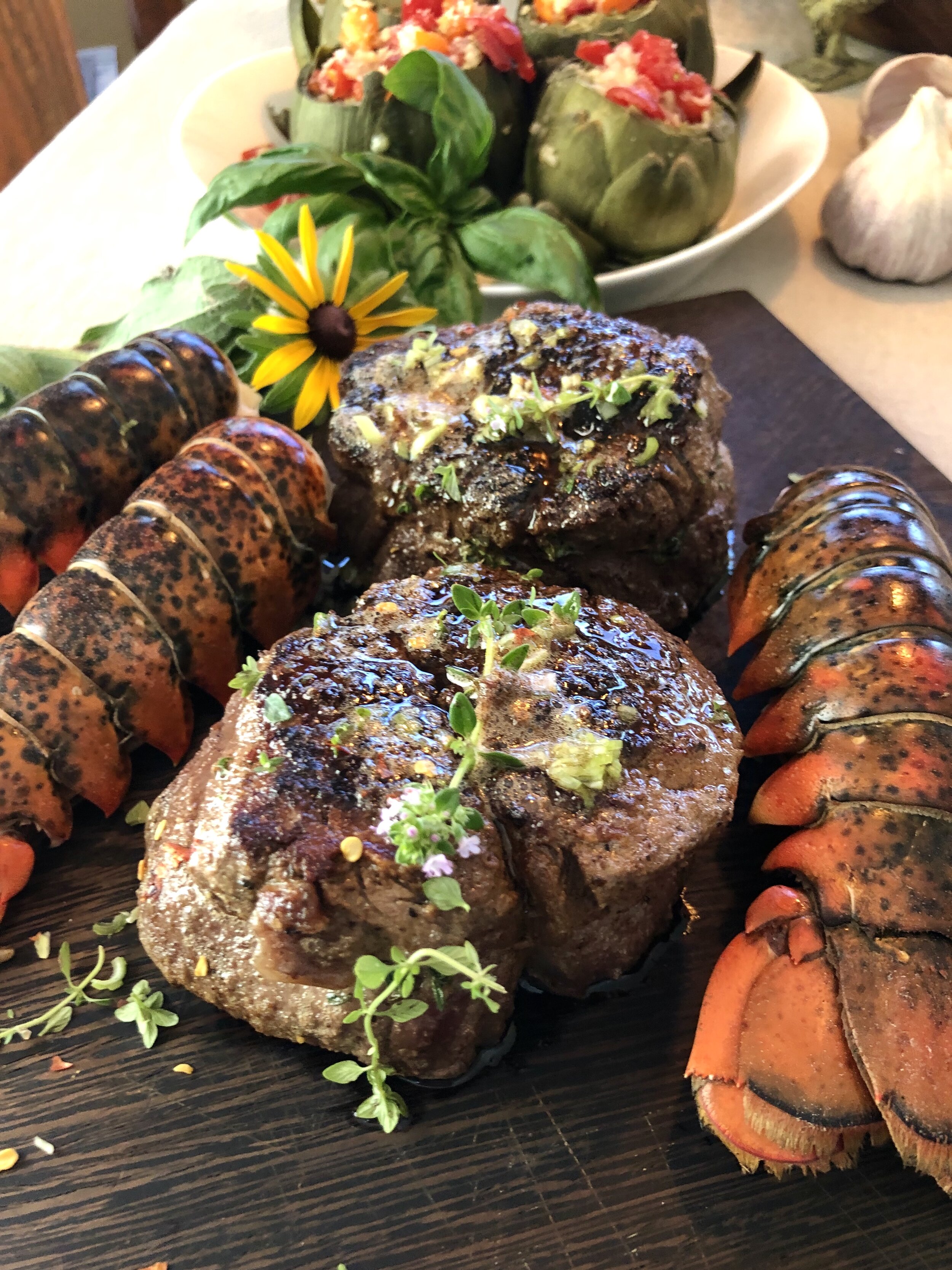 A delicate thyme and roasted garlic compound butter make this filet mignon extra special. And honestly, who does not love a little surf and turf?    You can have your fish monger steam up your tails  or simply add to a frypan with a touch of water and a tight fitted lid until the shells are bright red and your all done.