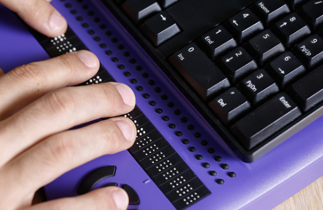 Person typing on a braille keyboard