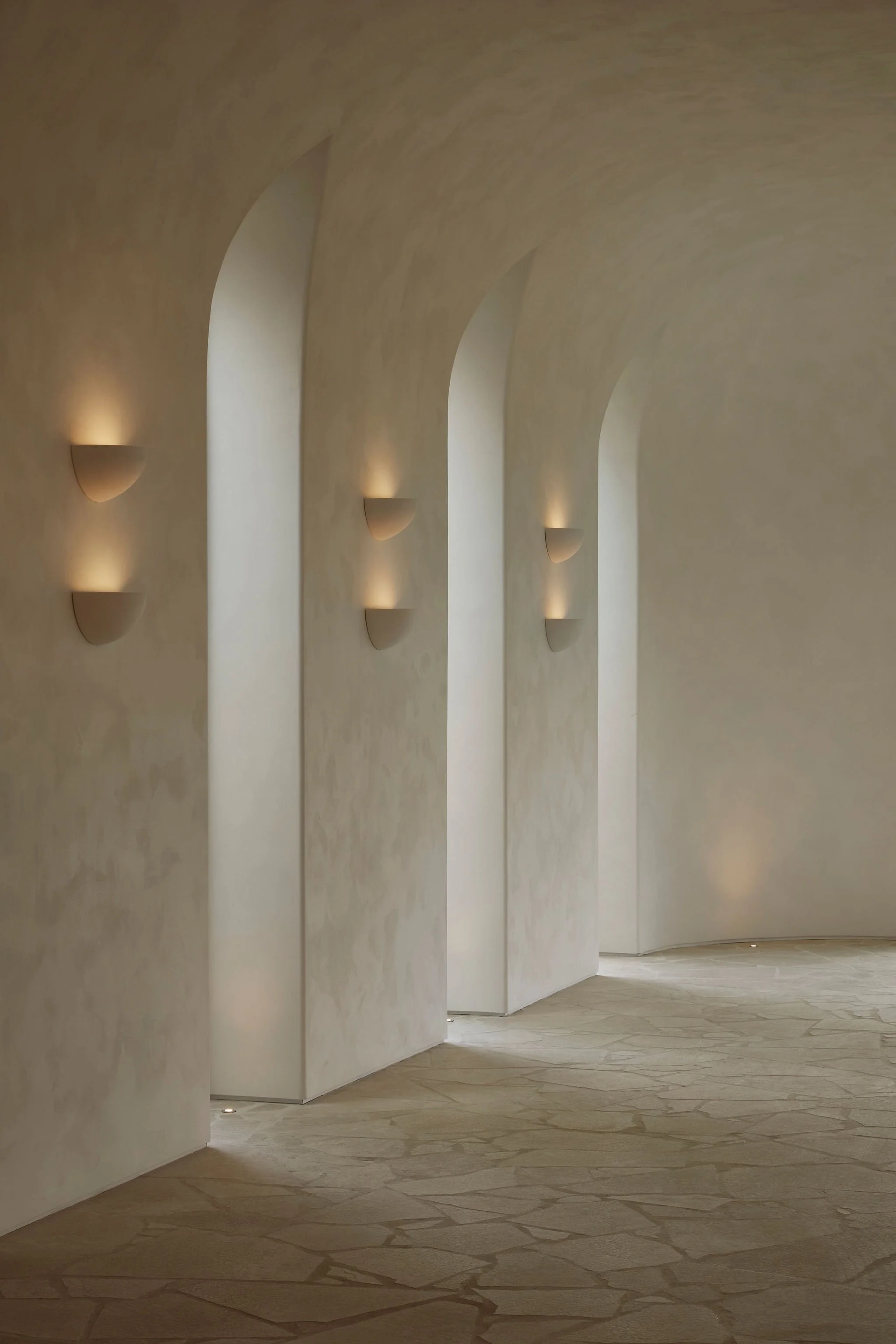 Curved plaster walls and arched openings inside the converted barn at Lune 1860 in Ontario.