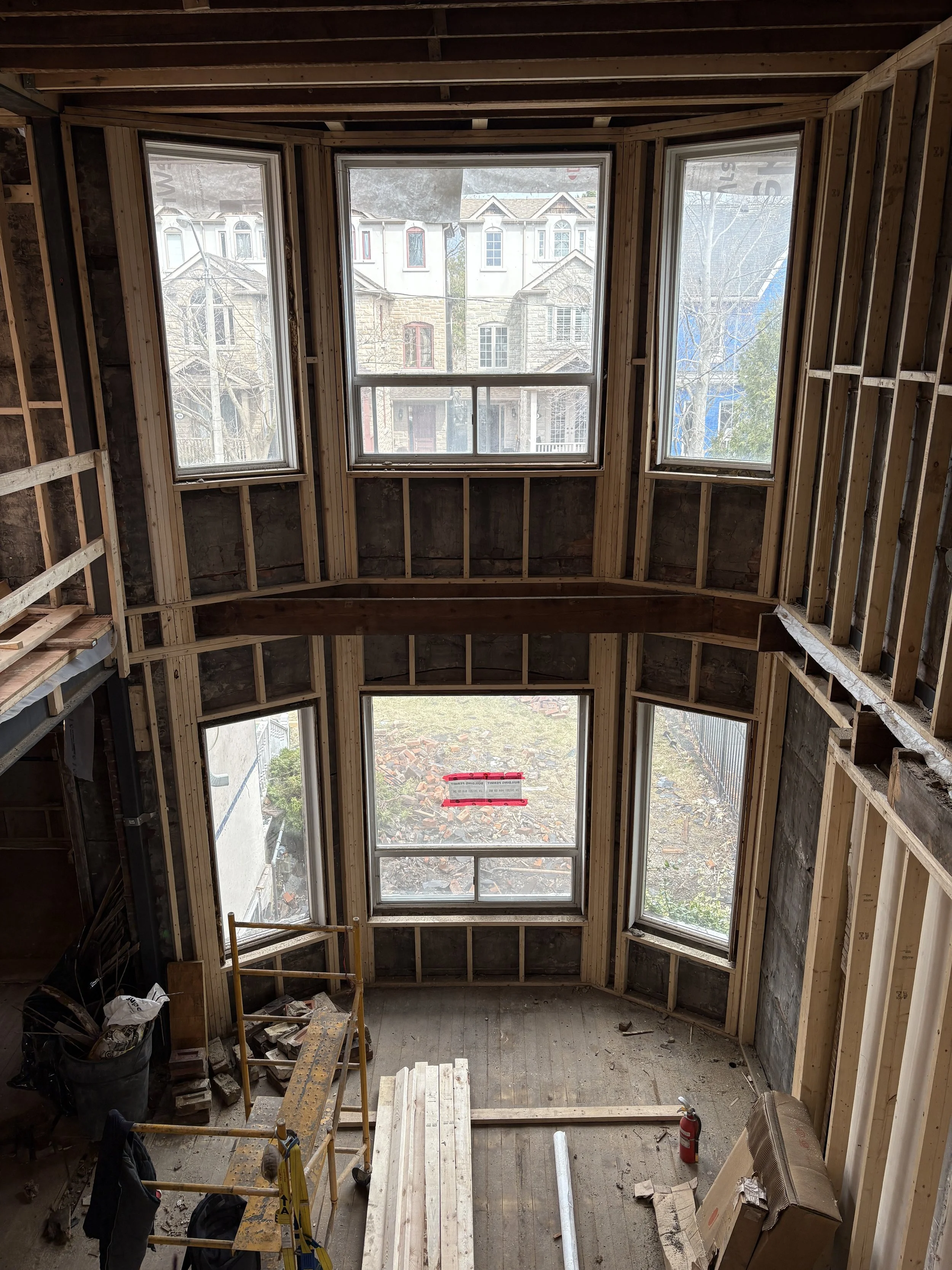 Existing-condition construction view at Riverdale Avenue showing the upper floor removed to create a new double-height living space within the existing Toronto home.