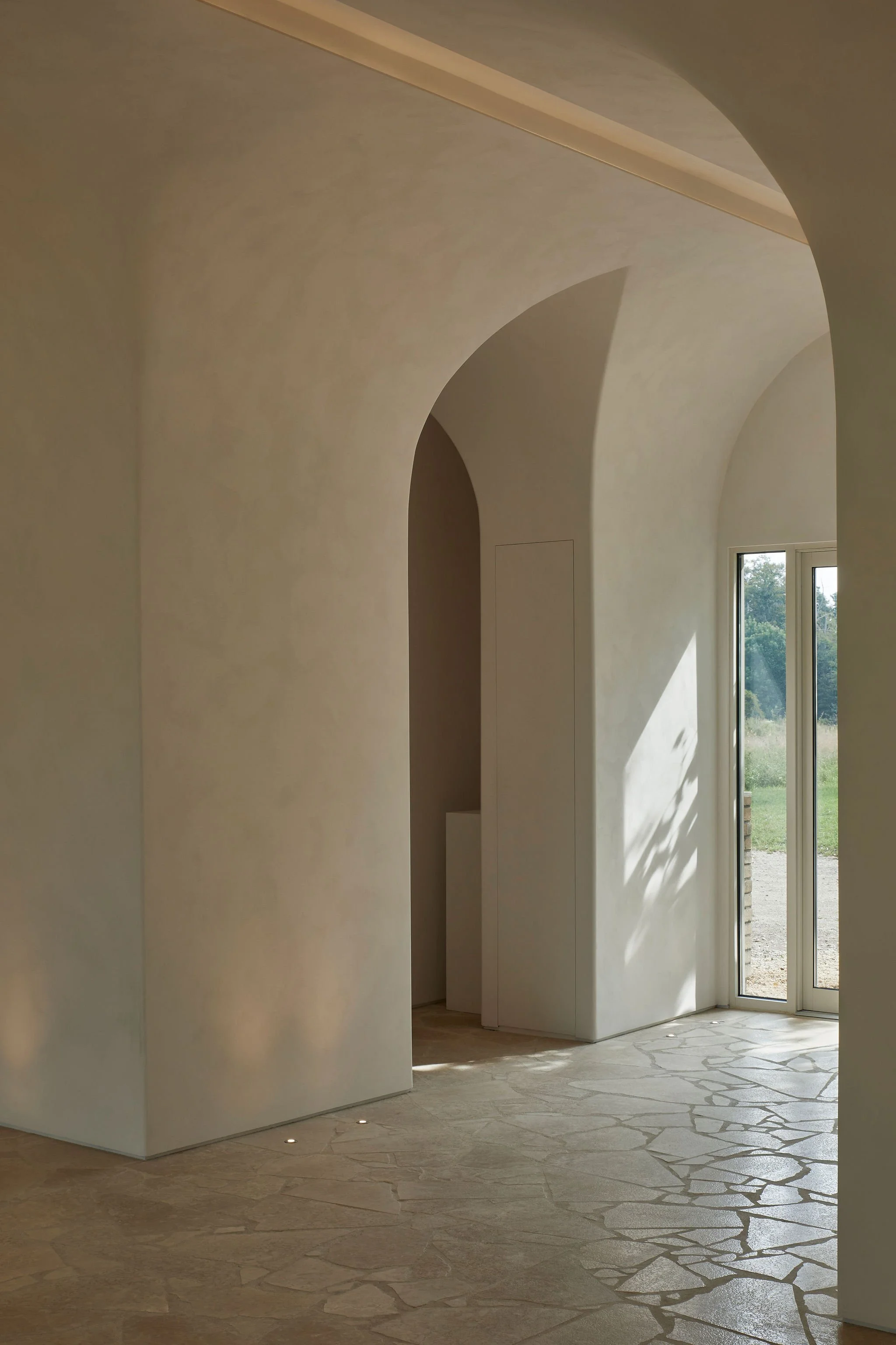 Main event space inside the Lune 1860 barn, with vaulted plaster ceiling, stone floor and views across the Ontario countryside.