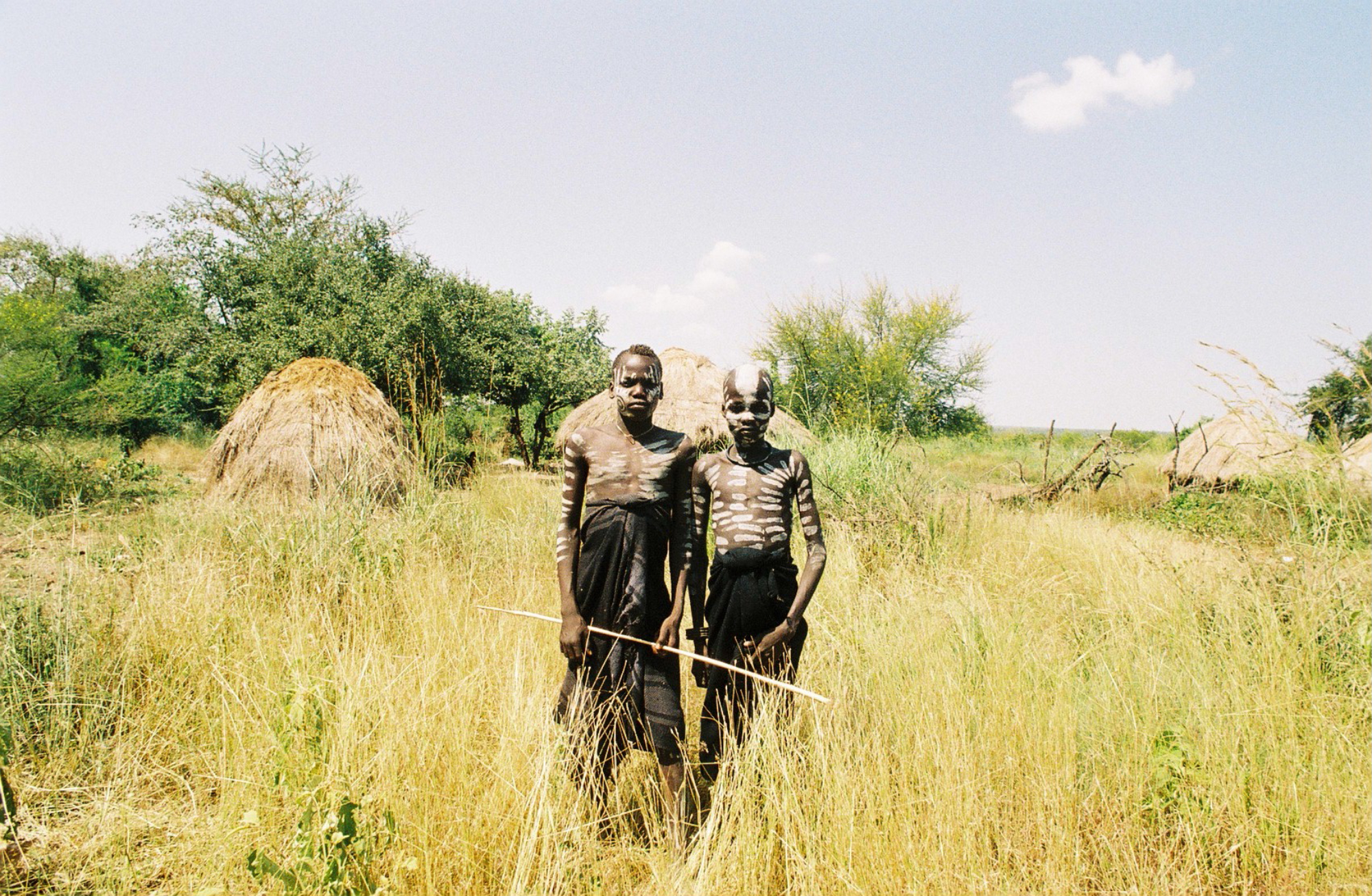  Two young members of the Mursi tribe in Ethiopia's Omo Valley stand stoically together. The community is becoming used to seeing tourists, and intentionally "dress-up" to capitalize on photo opportunities. As more tourists travel into the tribal reg