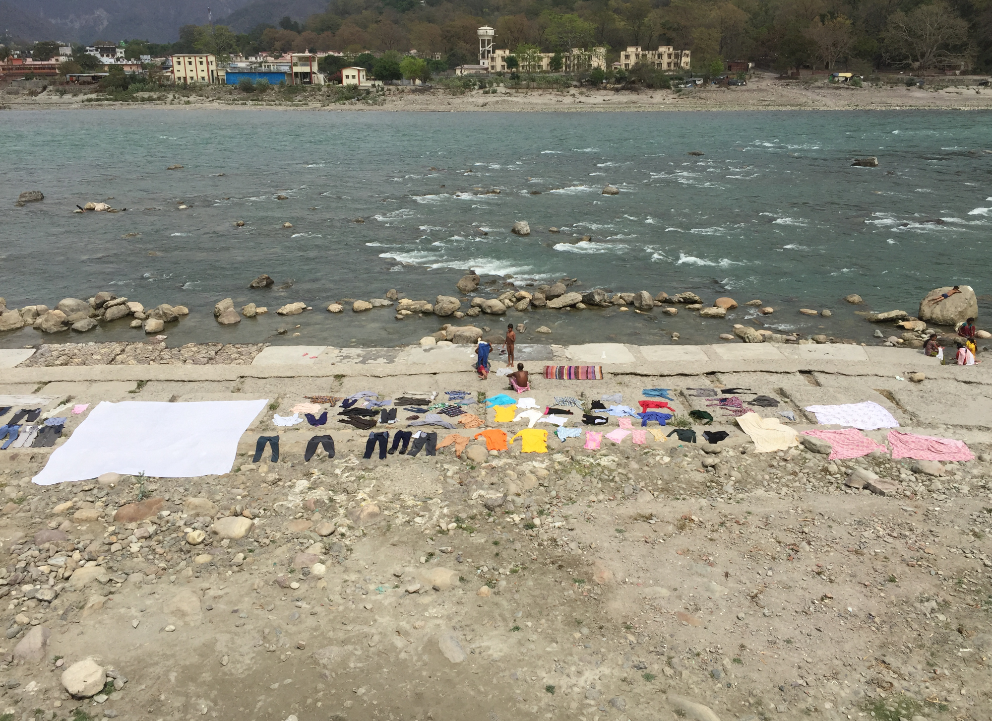 A family dries their laundry on the warm cement along the Ganges in Rishikesh, India.