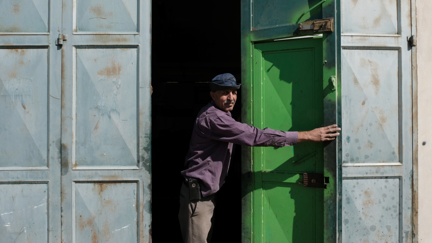  Mr. Abdalhade opens the door to his families olive pressing facilities. He and his 6 brothers worked together to finance and build the warehouse that serves Burin and the surrounding communities Irak Burin, Madama, Huwara, Asira Al-Qibliya, Urif. Fo