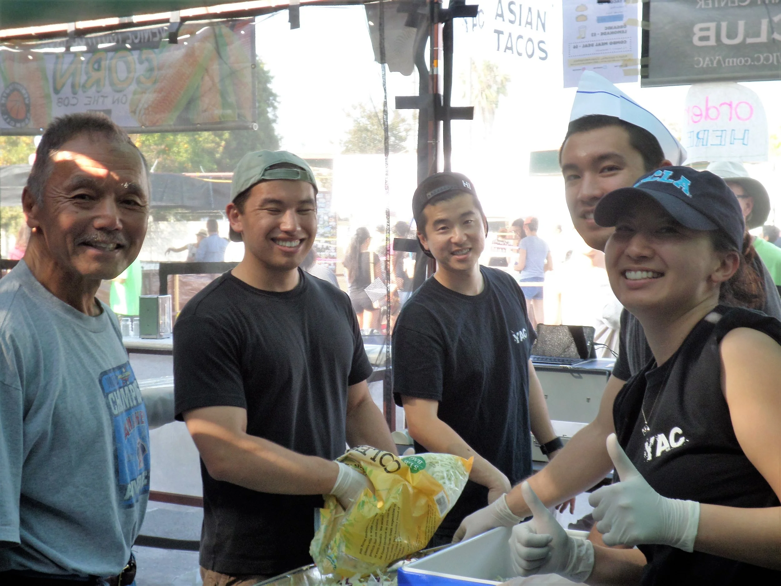 Boardmembers Keith Kawamoto and Steven Sharp volunteer for a shift at YAC's Taco Booth.