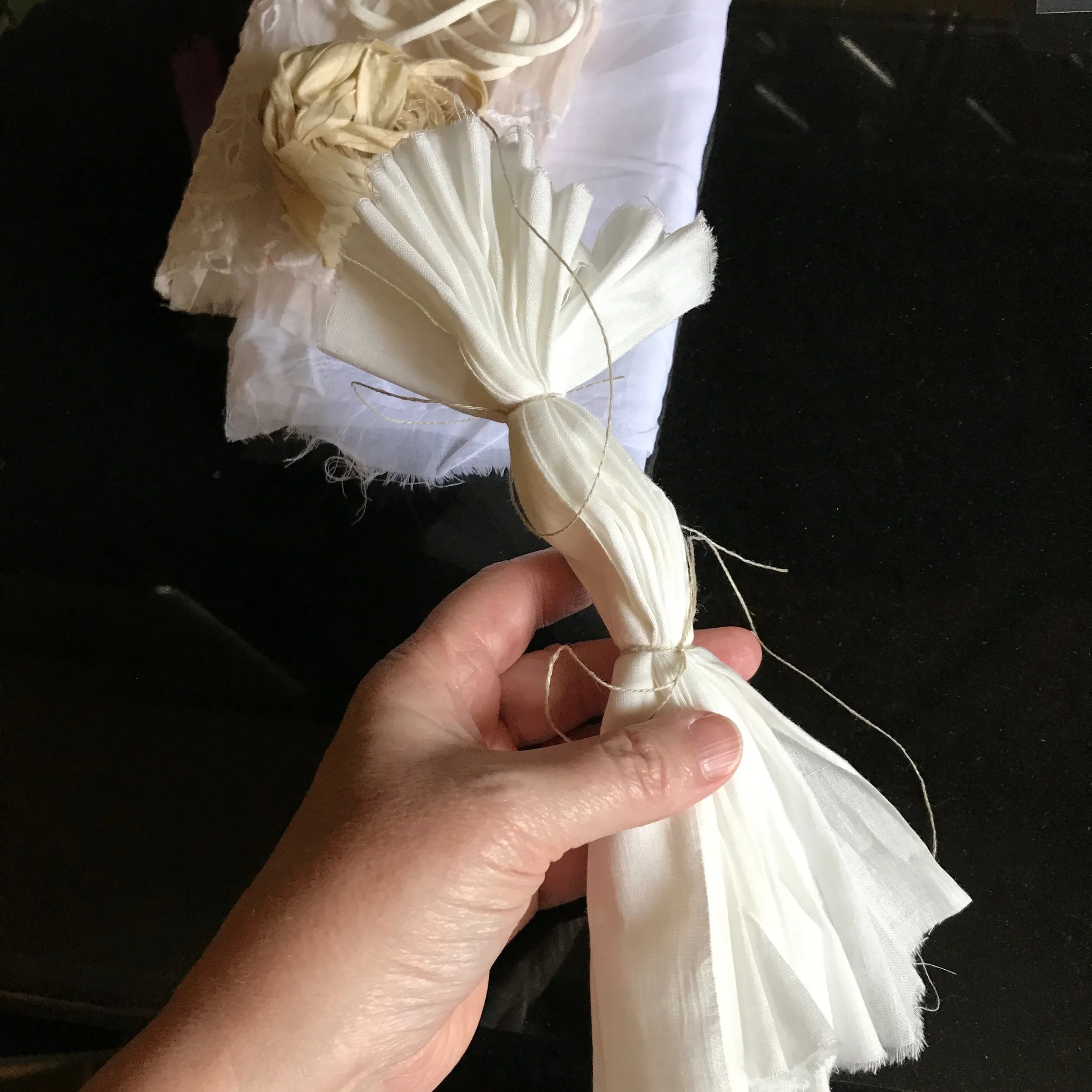4. While you're waiting for the water to boil, if you want to try a bit of tie-dyeing, prepare a piece of fabric for that now but some combination of folding and banding. I decided to give it a try with my largest piece of fabric—the cotton.