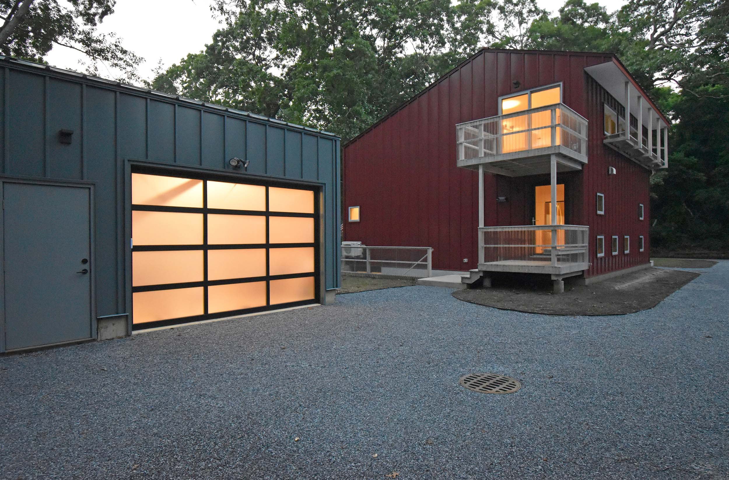  Evening view from the driveway toward east, seeing house (red) and garage (gray) (photo: studio a/b architects) 