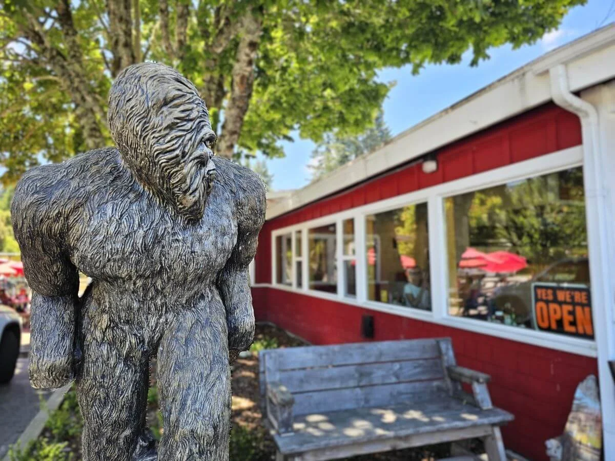 Statue of a sasquatch outside a red cafe building near Redwoods in California