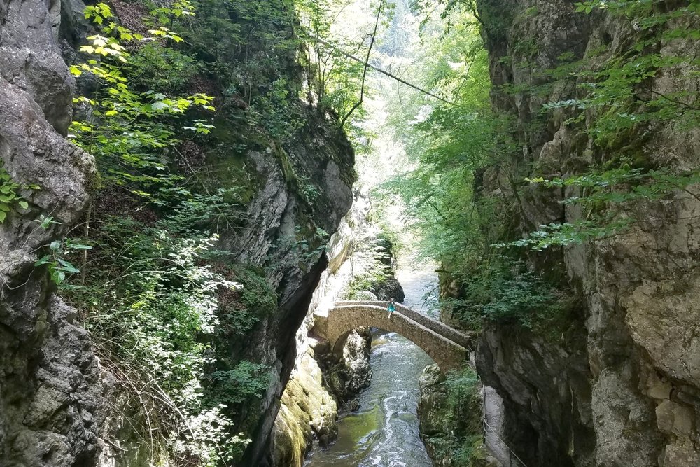 The best Switzerland itinerary for 5 days involves a stop at the stone bridge in Areuse Gorge. This Switzerland road trip itinerary will help you plan your route to see darling villages, emerald lakes, gorgeous castles, soaring mountains and more!