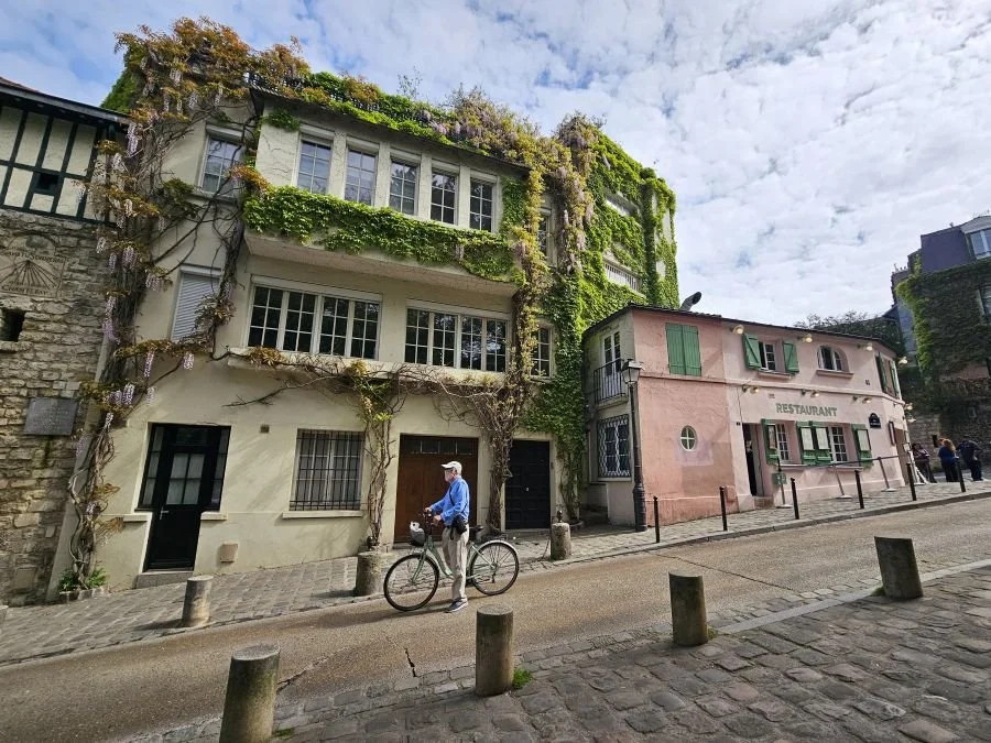 Paris street with a pink building covered in vines