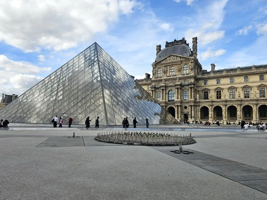 The Louvre museum in paris with a glass pyramid in front