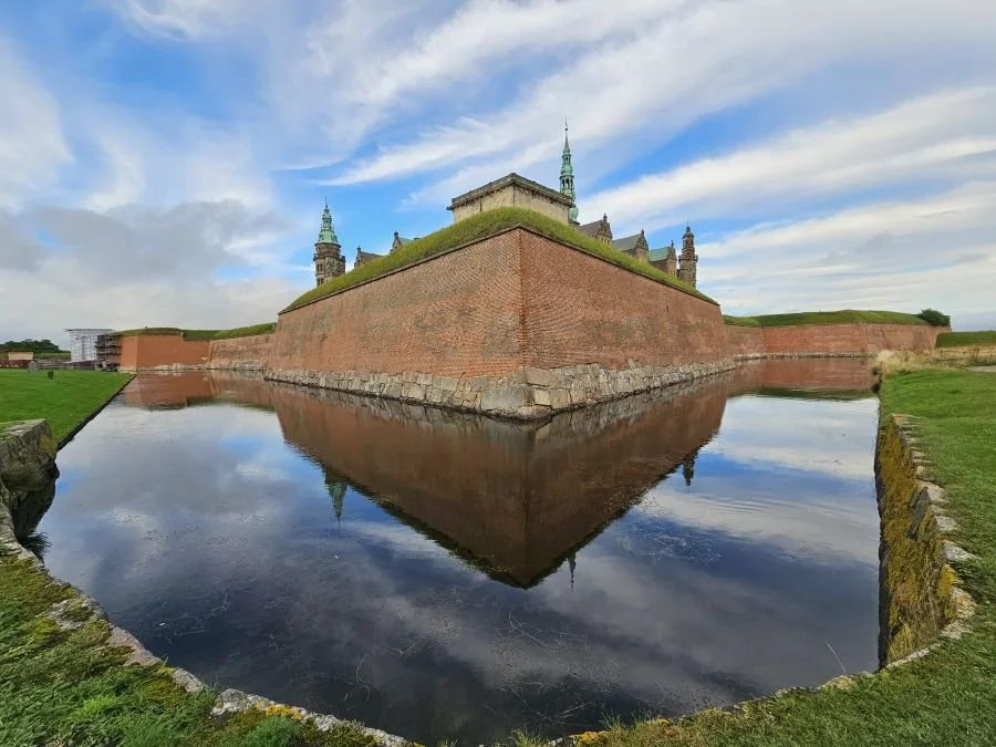 castle with a moat and a text overlay that says Denmark
