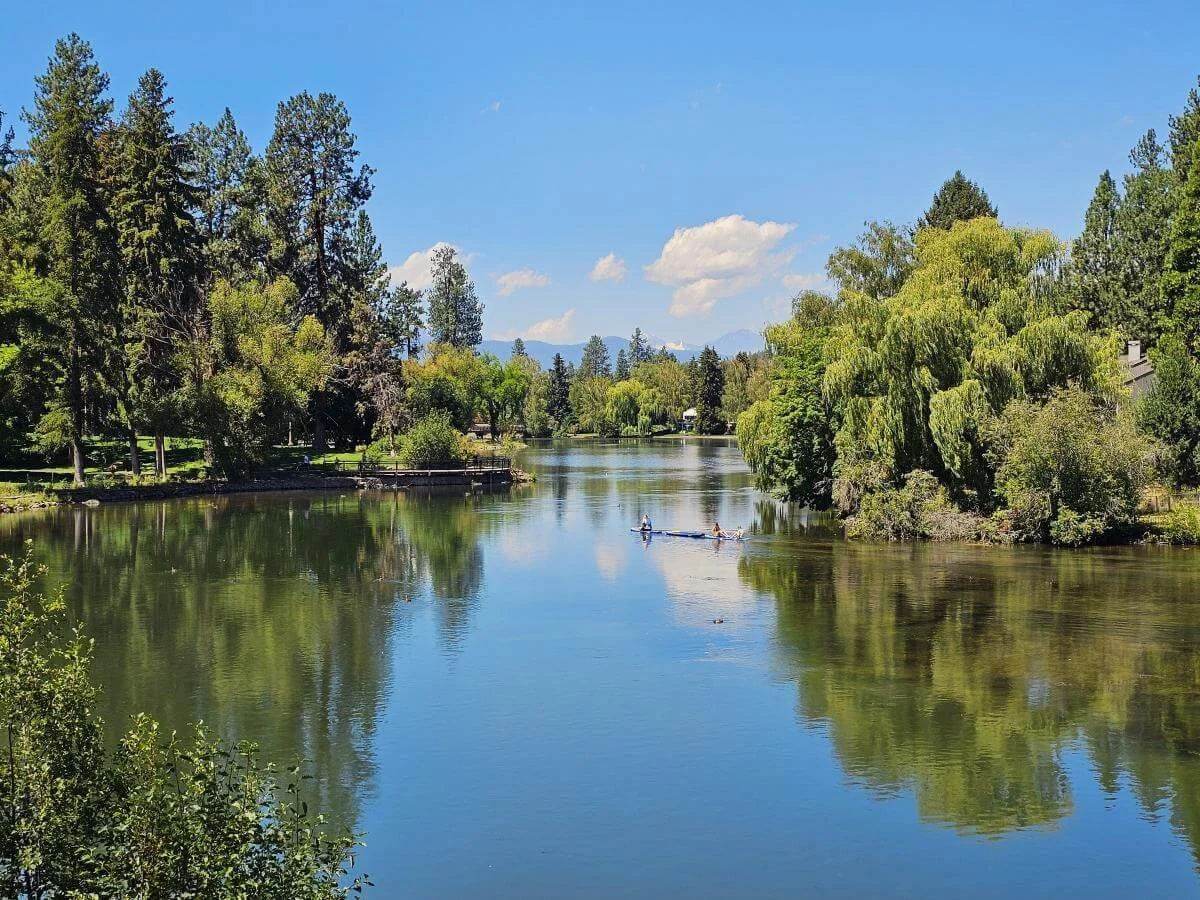 A river with trees on the banks reflected in the water in Bend, Oregon