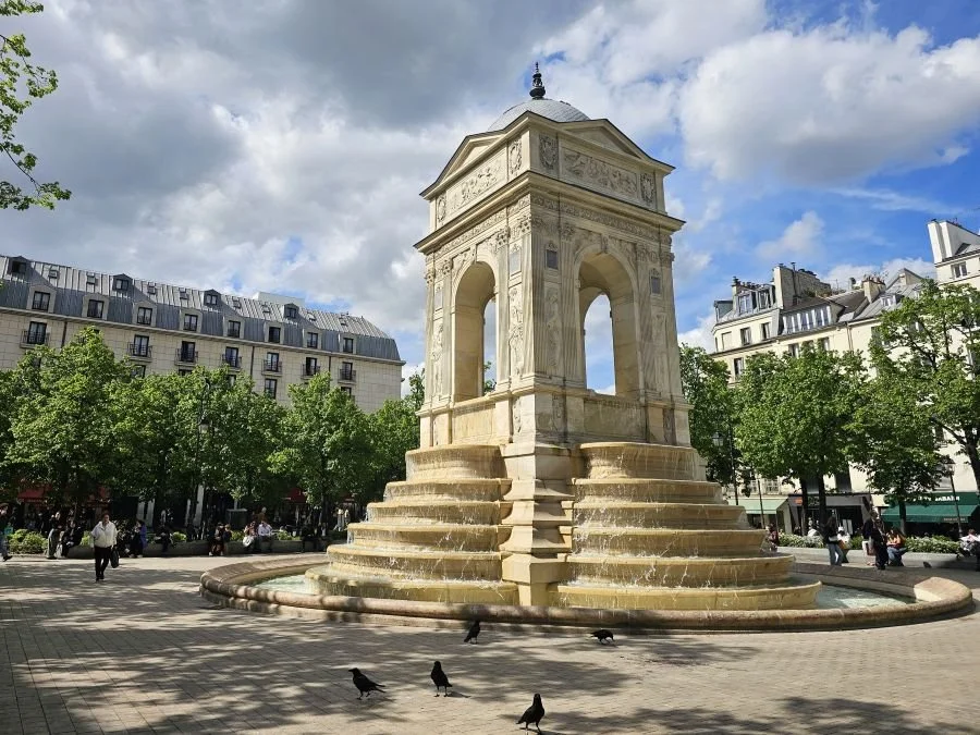 A monument and fountain in a square in Paris