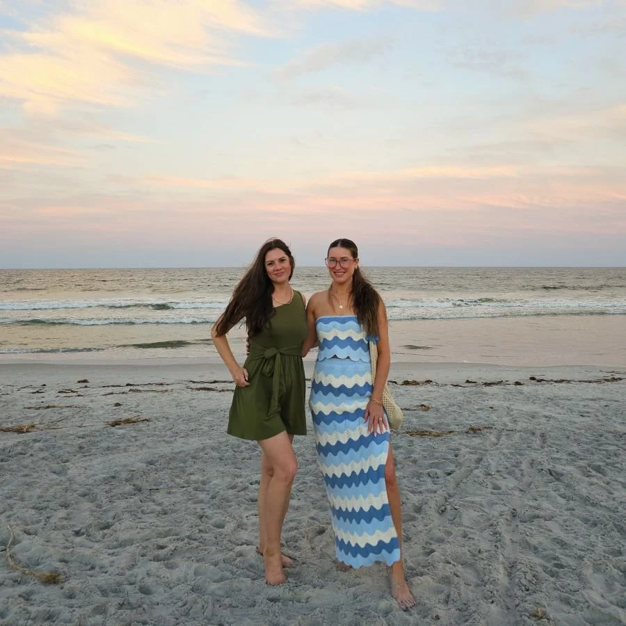 Two women stand next to each other on the beach on a girls weekend in the south
