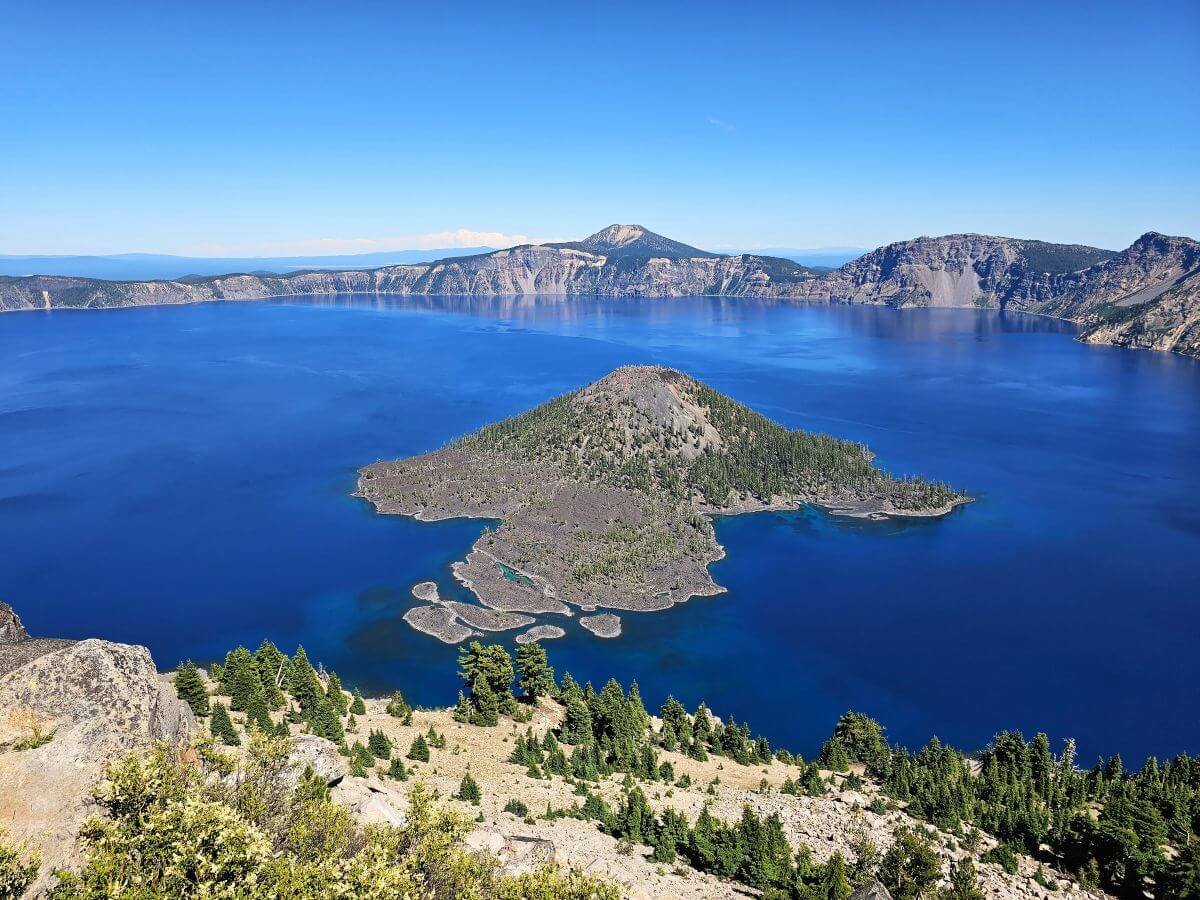 A huge sapphire blue lake with an island in the middle at Crater Lake National Park in Oregon