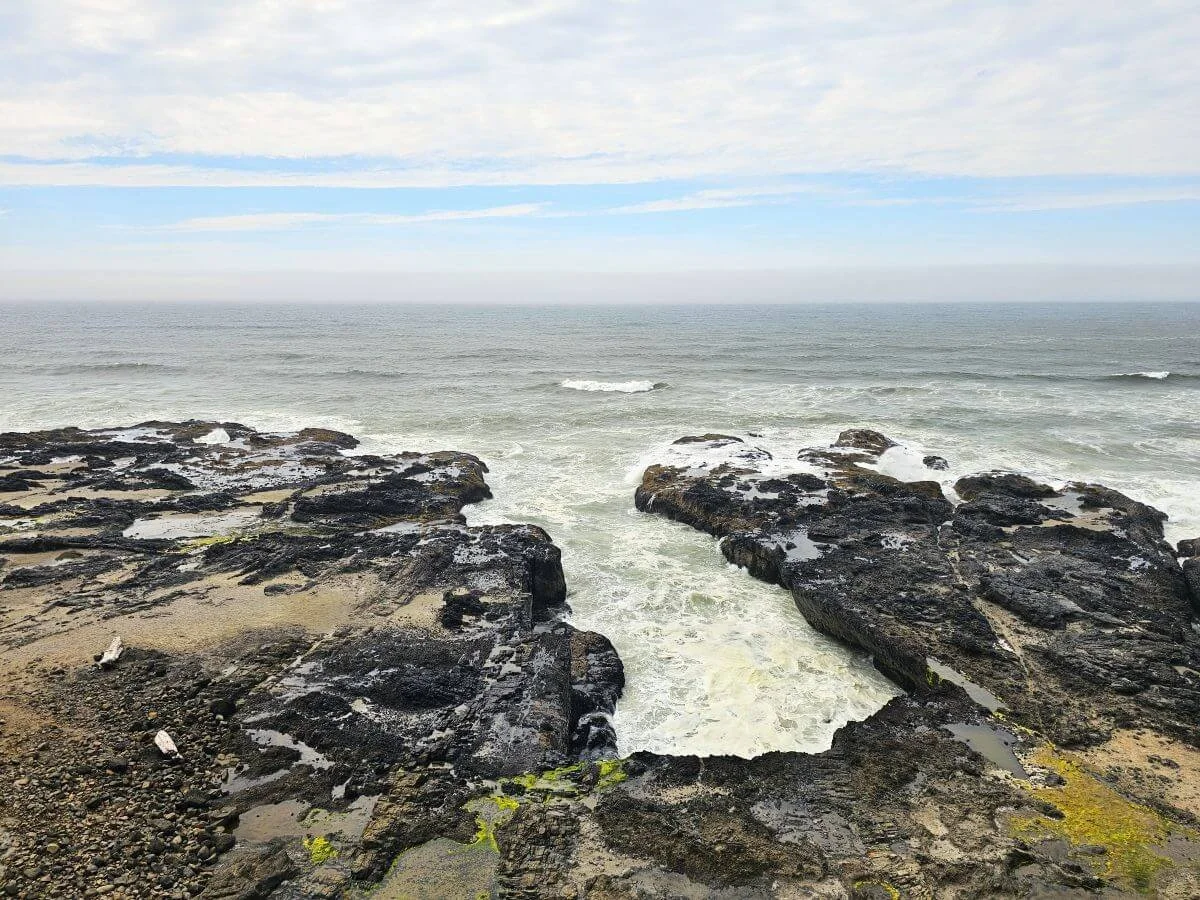 Black volcanic rock with crashing waves on the coast of Oregon