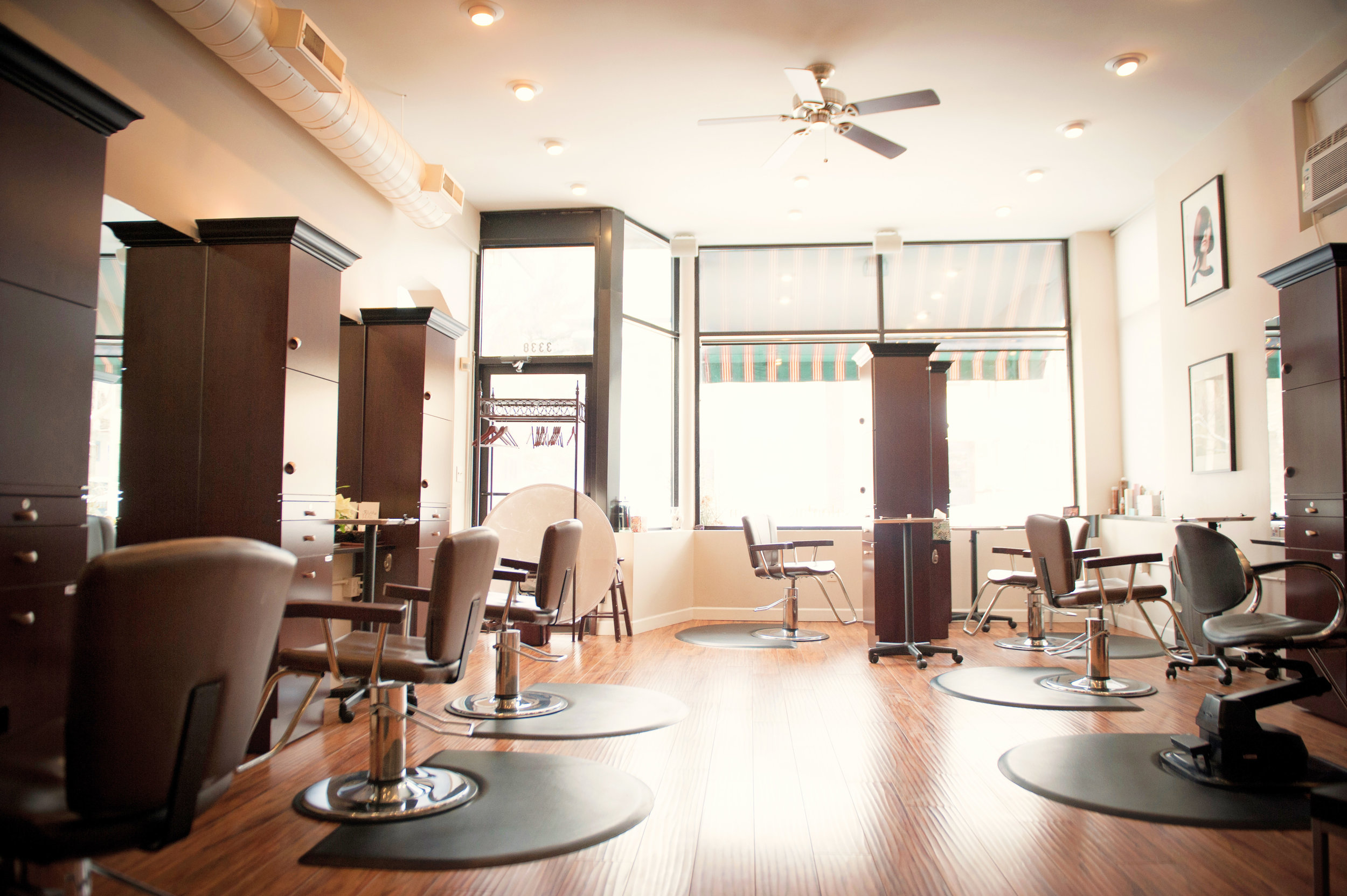 Salon La Terre hair stations with brown chairs and large windows
