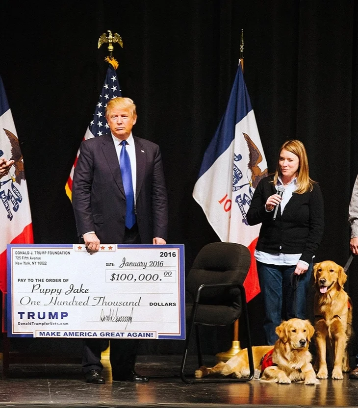 Donald Trump presents a check to the Puppy Jake Foundation while campaigning in Iowa in 2016 ( Image )