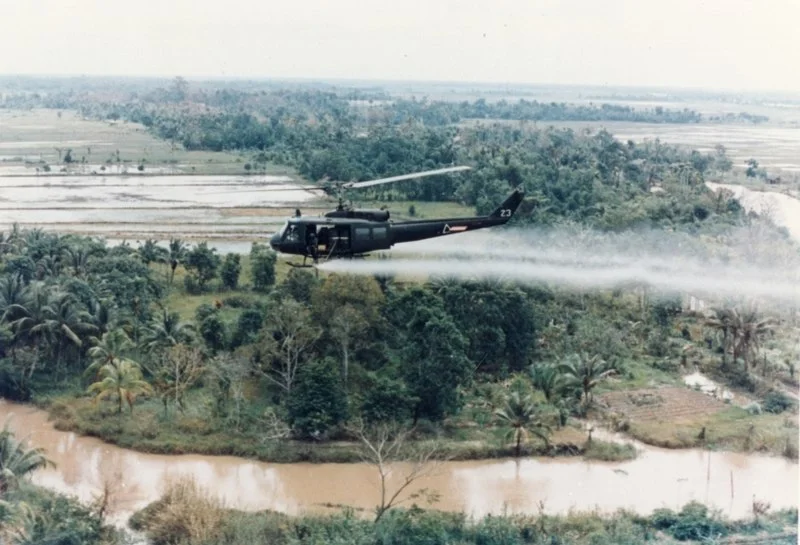 An overview shot of a US Helicopter spraying Agent Orange in Vietnam ( source )