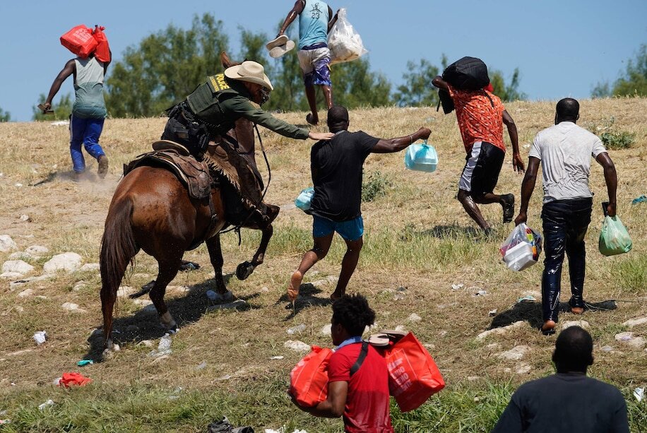 A border agent attempts to apprehend a Haitian migrant at the southern border. Source: Washington Post