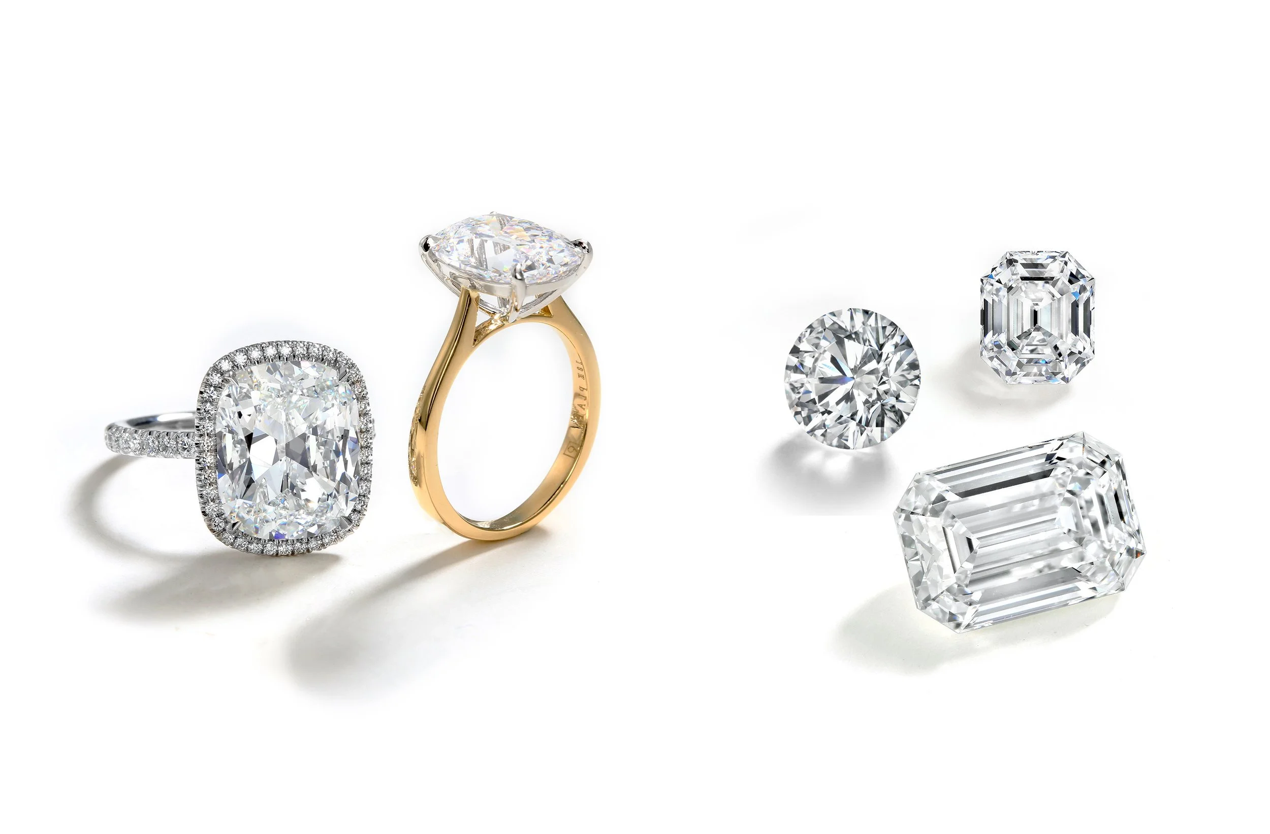 Two diamond rings and four loose diamonds on a white background.